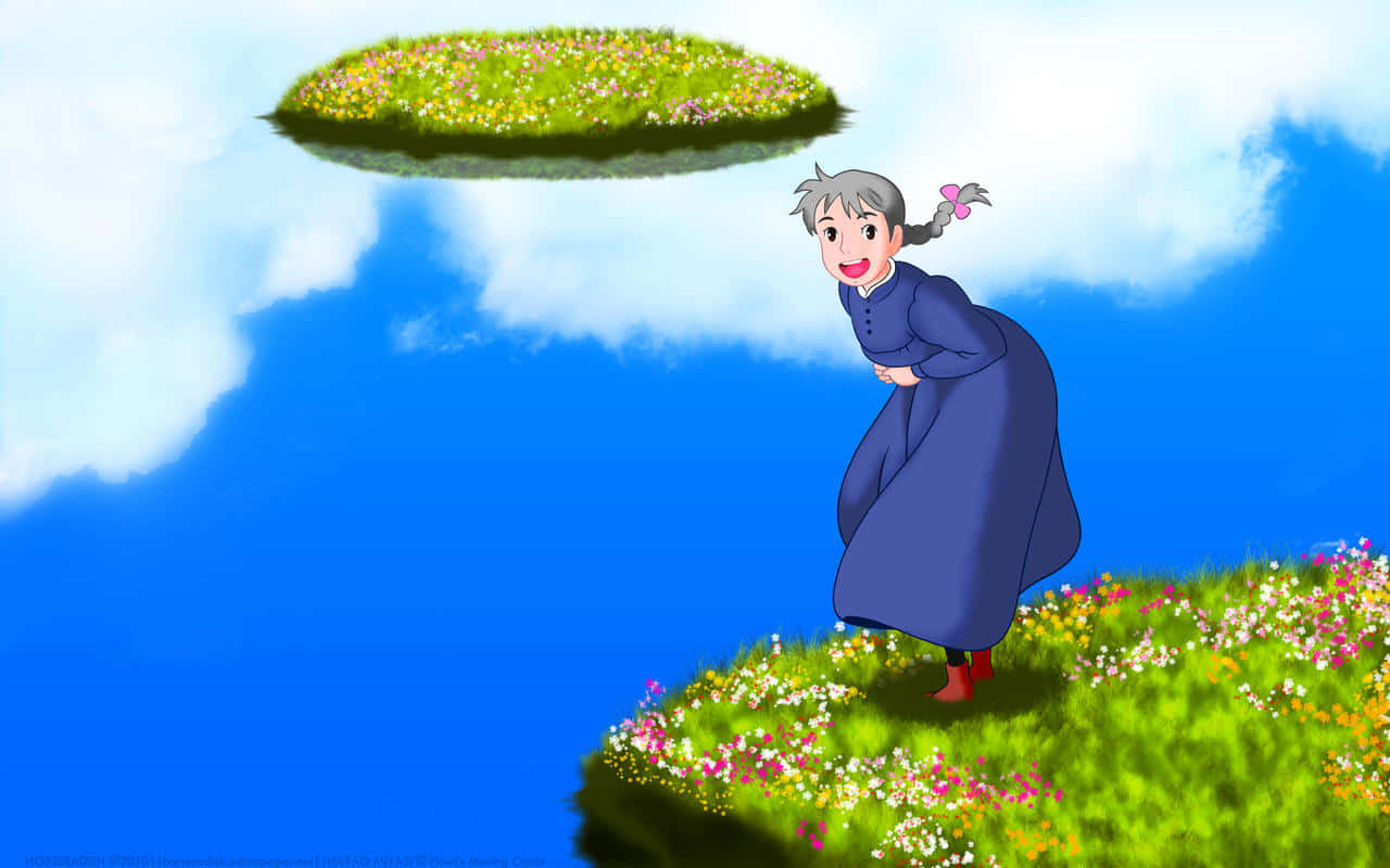 《霍爾的移動城堡》可愛蘇菲笑容畫面 壁紙 — 一位身穿藍色連衣裙的開朗老婦人站在一個長滿草和花的浮島上，背景是明亮的藍天和蓬鬆的白雲。