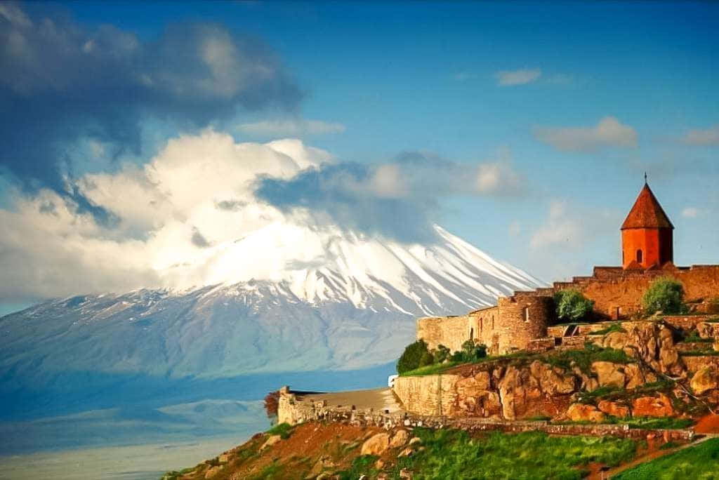 懸崖上的古老石堡，背景有積雪山峰