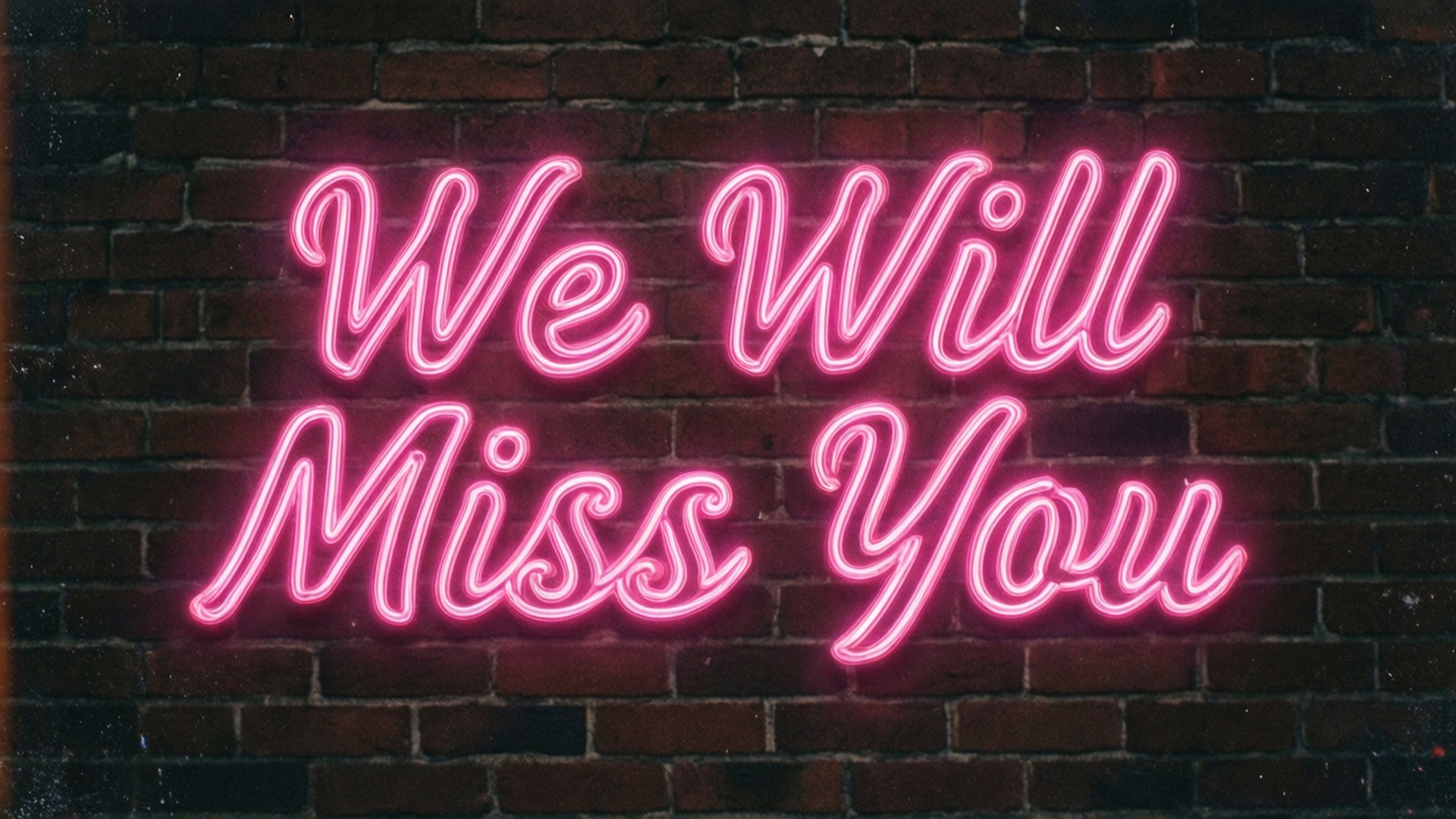 夜晚磚牆上寫著 We Will Miss You 的粉紅色霓虹燈牌。