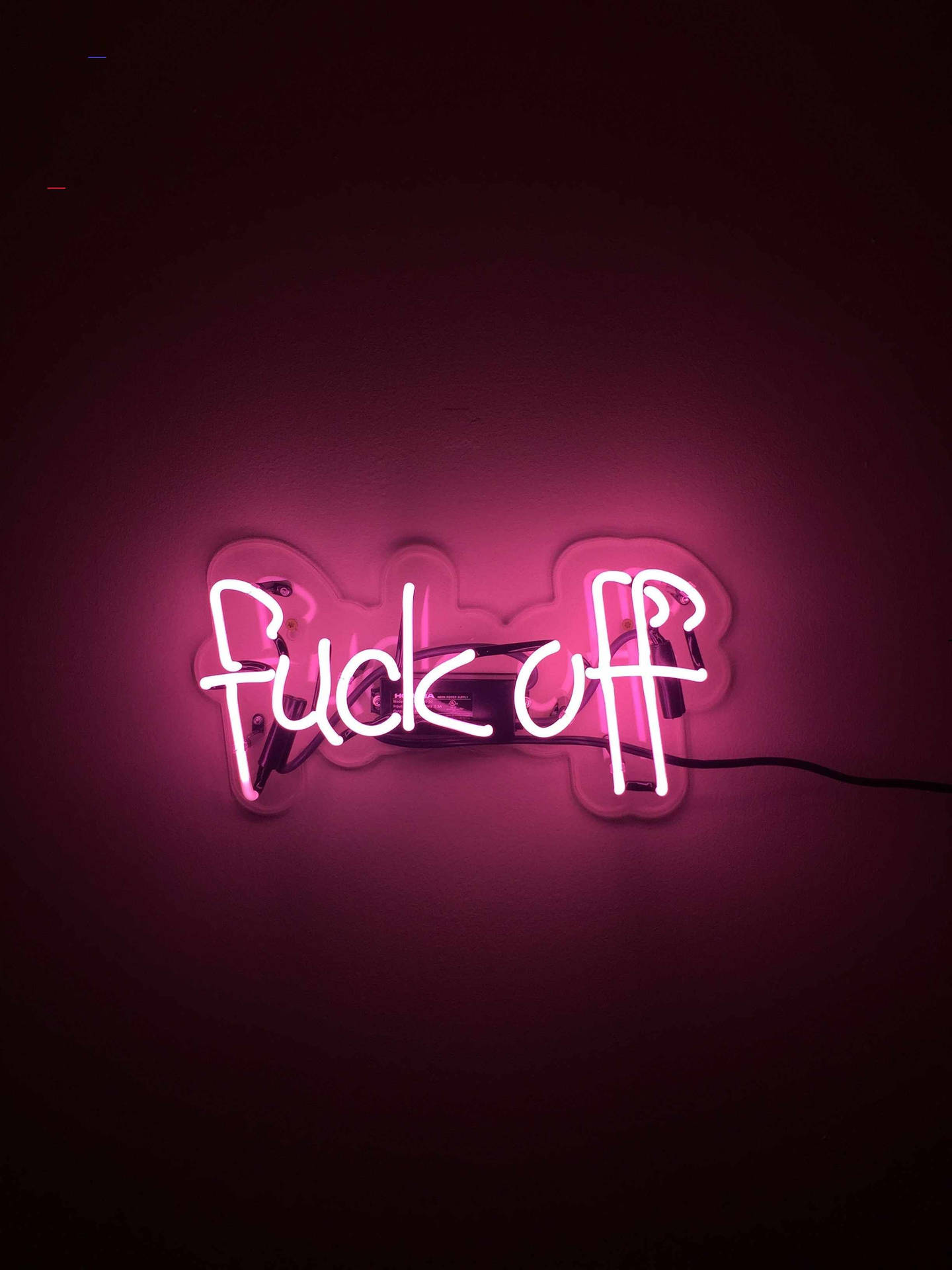 安裝在黑暗牆壁上的粉紅色霓虹燈牌，上面寫著「fuck off」。
