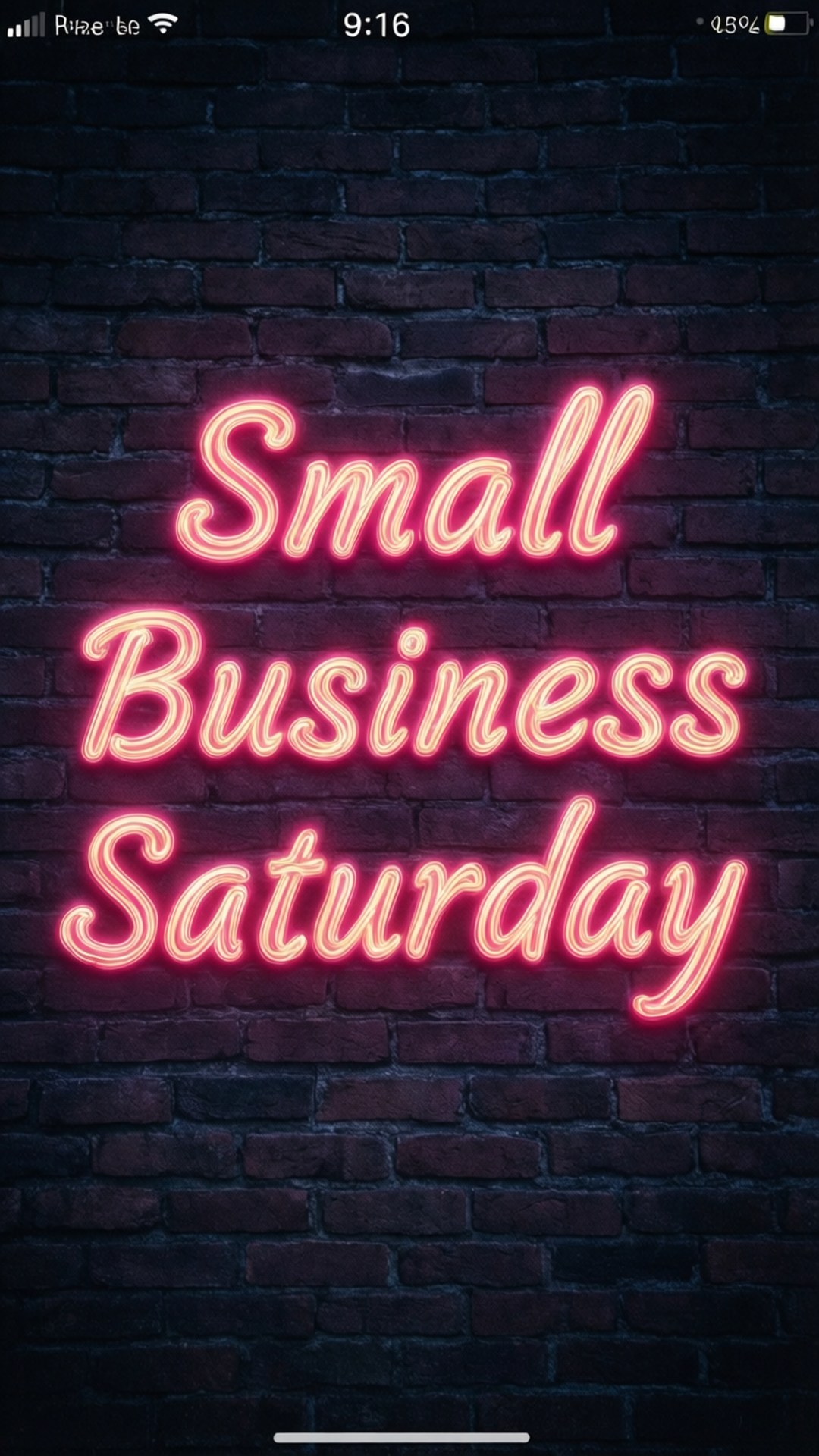 夜間磚牆上寫著「Small Business Saturday」的粉紅色霓虹燈牌。