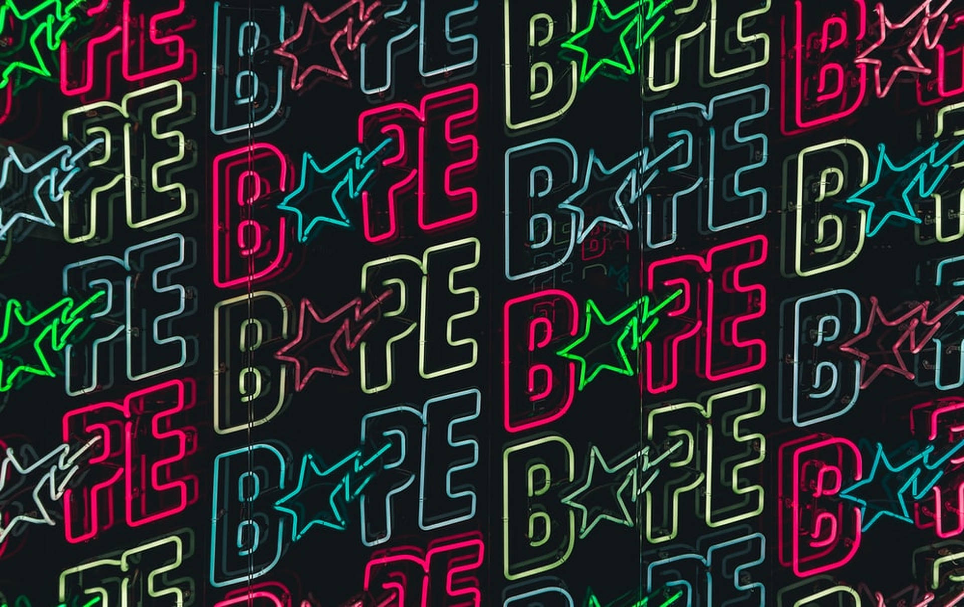 在深色牆壁上發光的霓虹 BAPE 標誌和星星標誌。
