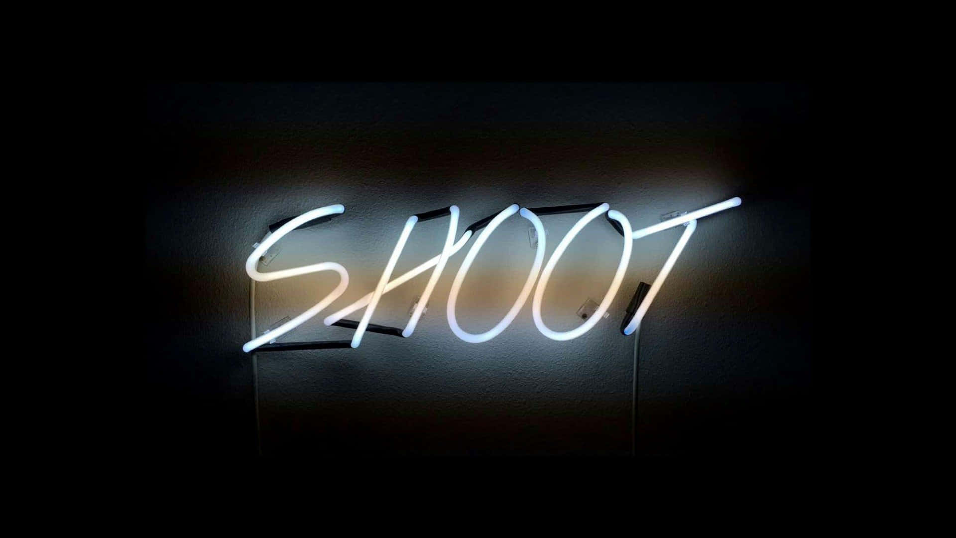一個發光的霓虹燈牌，上面寫著 SHOOT，安裝在深色牆壁上。