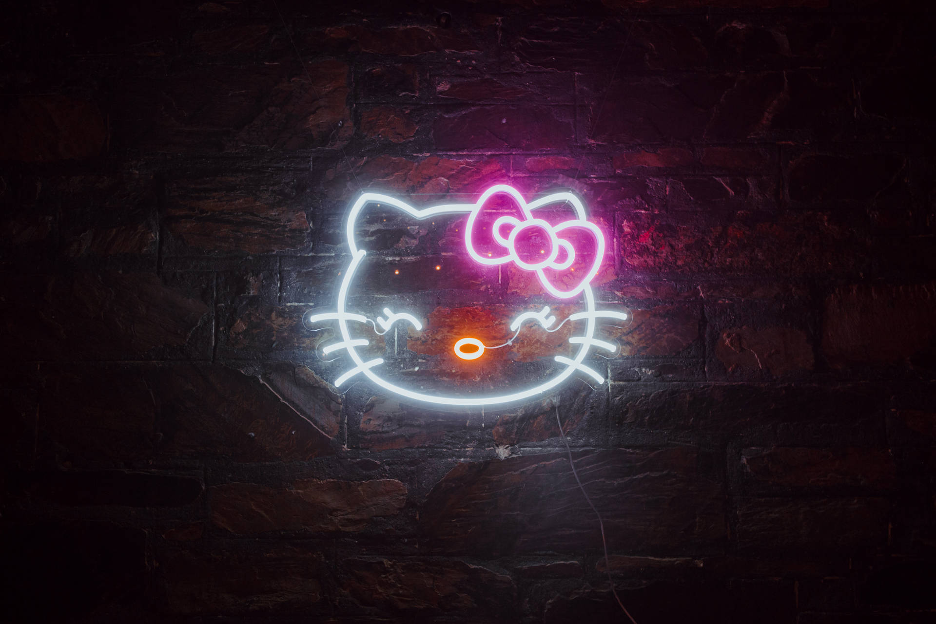 Hello Kitty霓虹燈牌在夜間的深色磚牆上發光。