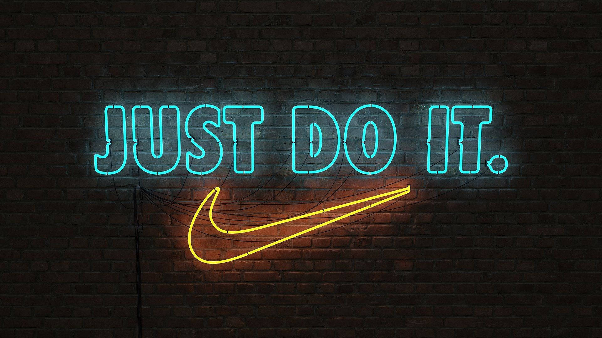 霓虹燈招牌上的「Just Do It」與Nike標誌 壁紙 — 一個發光的霓虹燈牌，上面有青色的「JUST DO IT」和黃色的勾號，背景是深色磚牆。