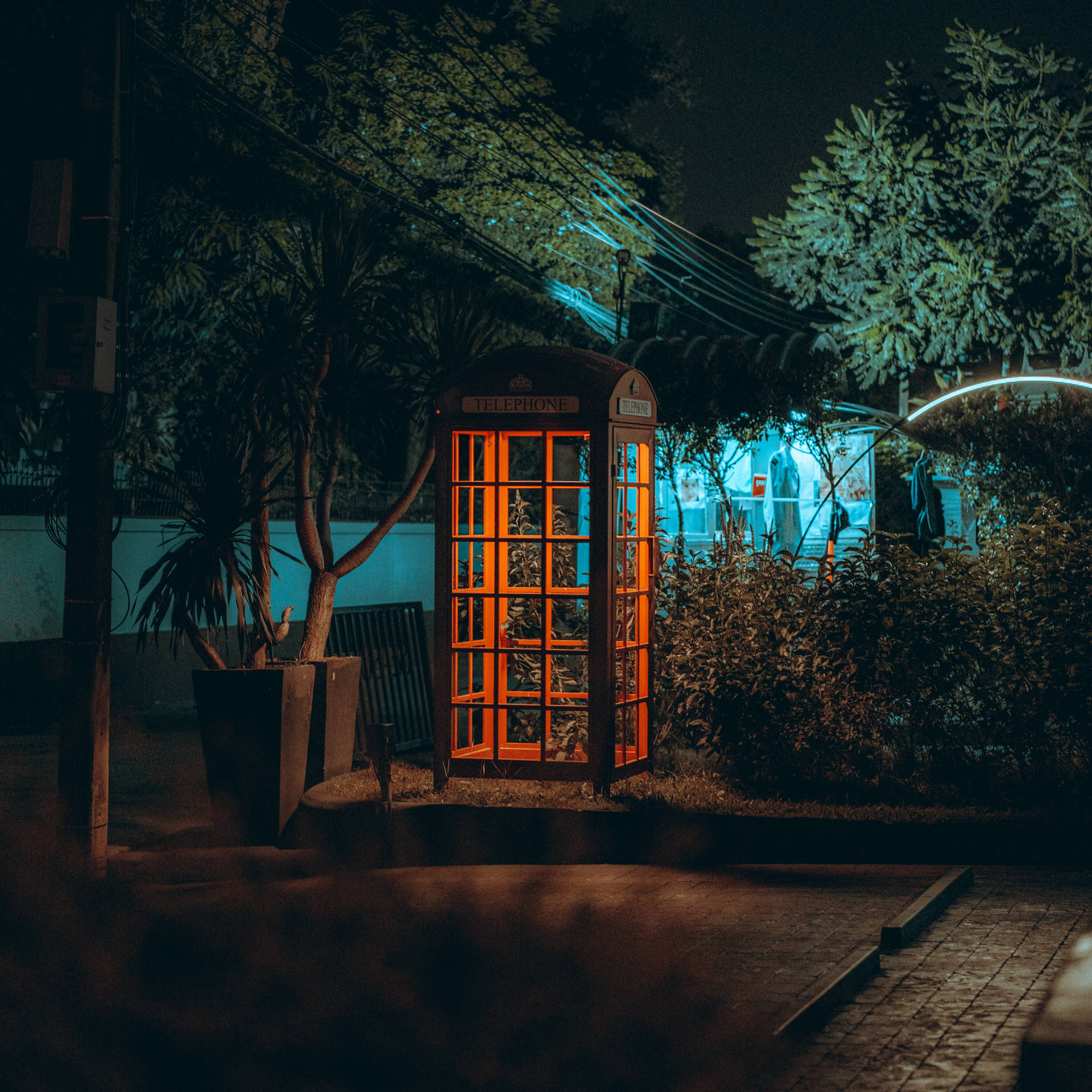 夜晚在城市環境中亮起的復古橙色電話亭。