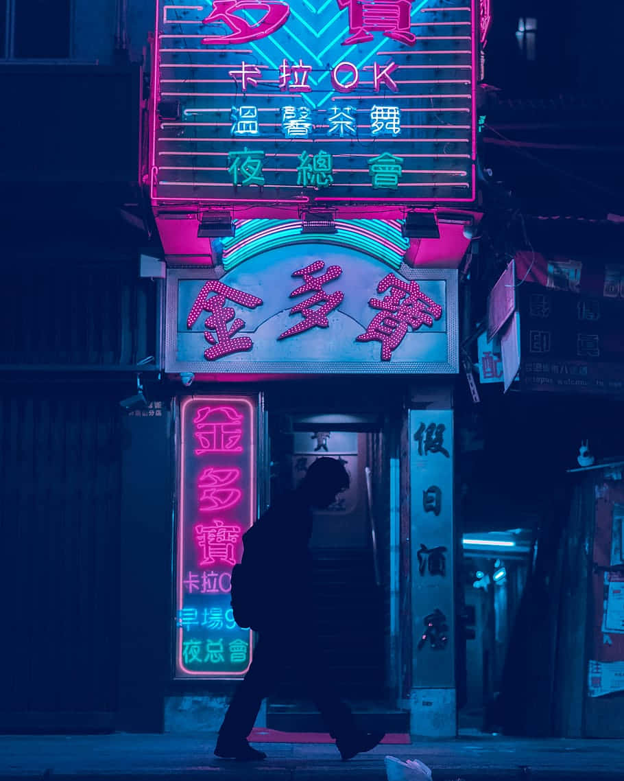 一個人在黑暗的城市小巷中走過發光的霓虹燈標誌。
