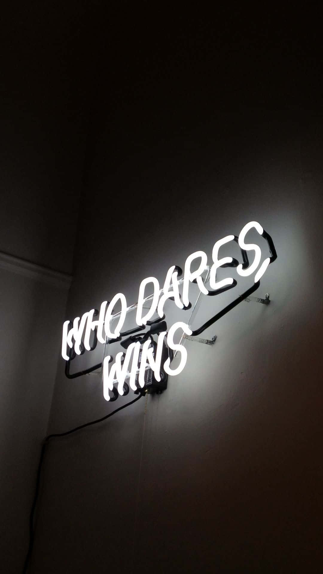 一個白色霓虹燈牌，在深色牆壁上寫著 who dares wins。