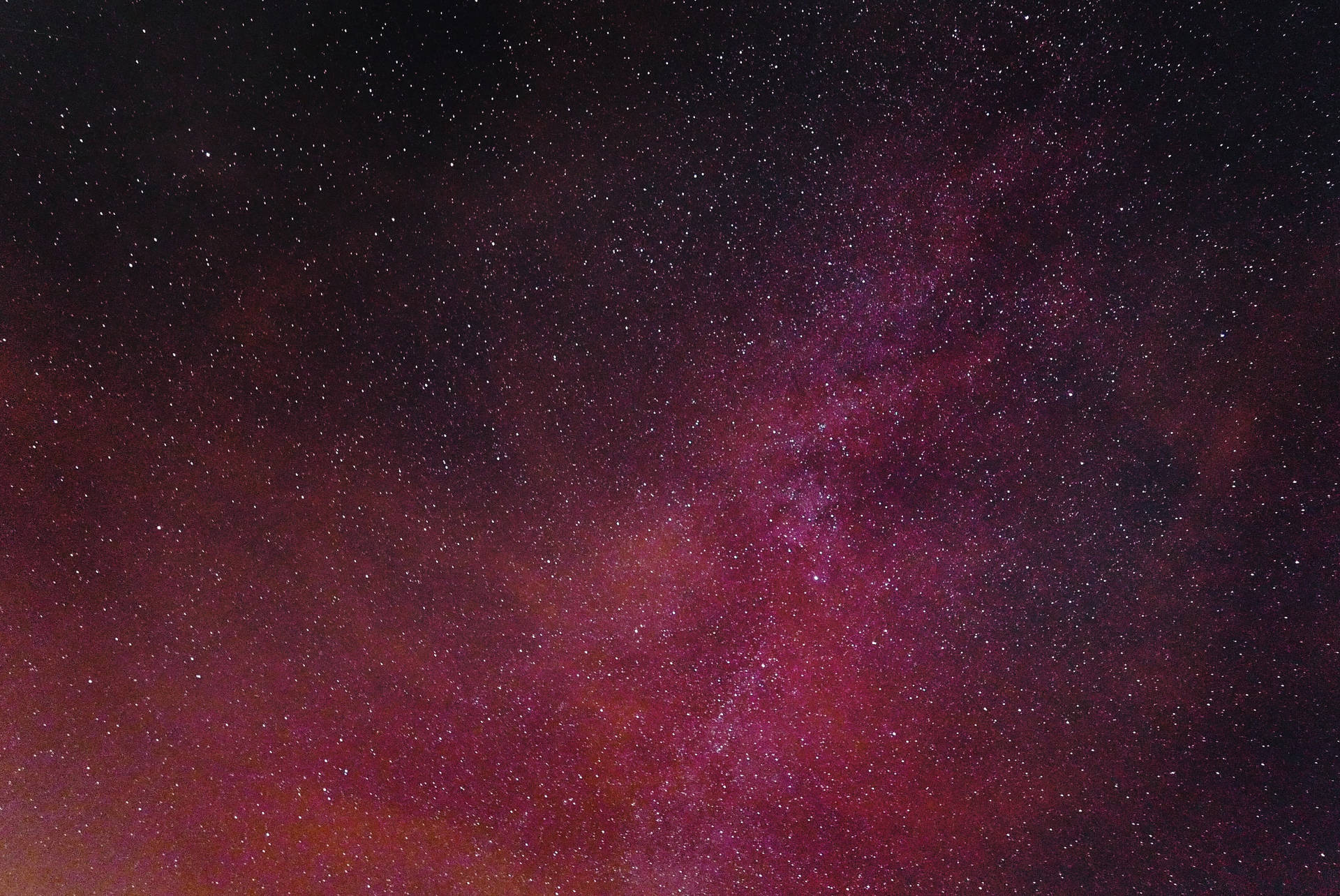在深邃的夜空中，無數星星與充滿活力的紫色和洋紅色星雲。