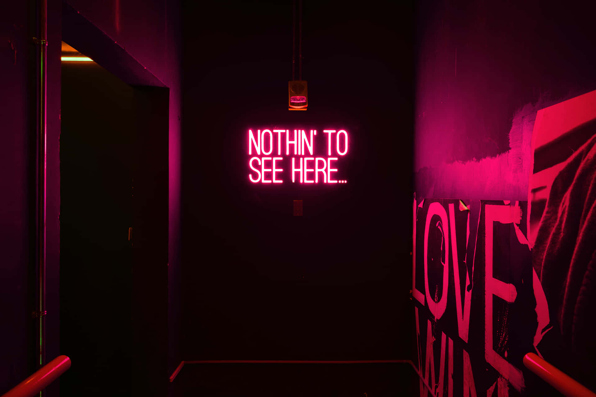 一條黑暗的走廊，有一個發光的粉紅色霓虹燈牌，上面寫著「NOTHIN' TO SEE HERE...」。