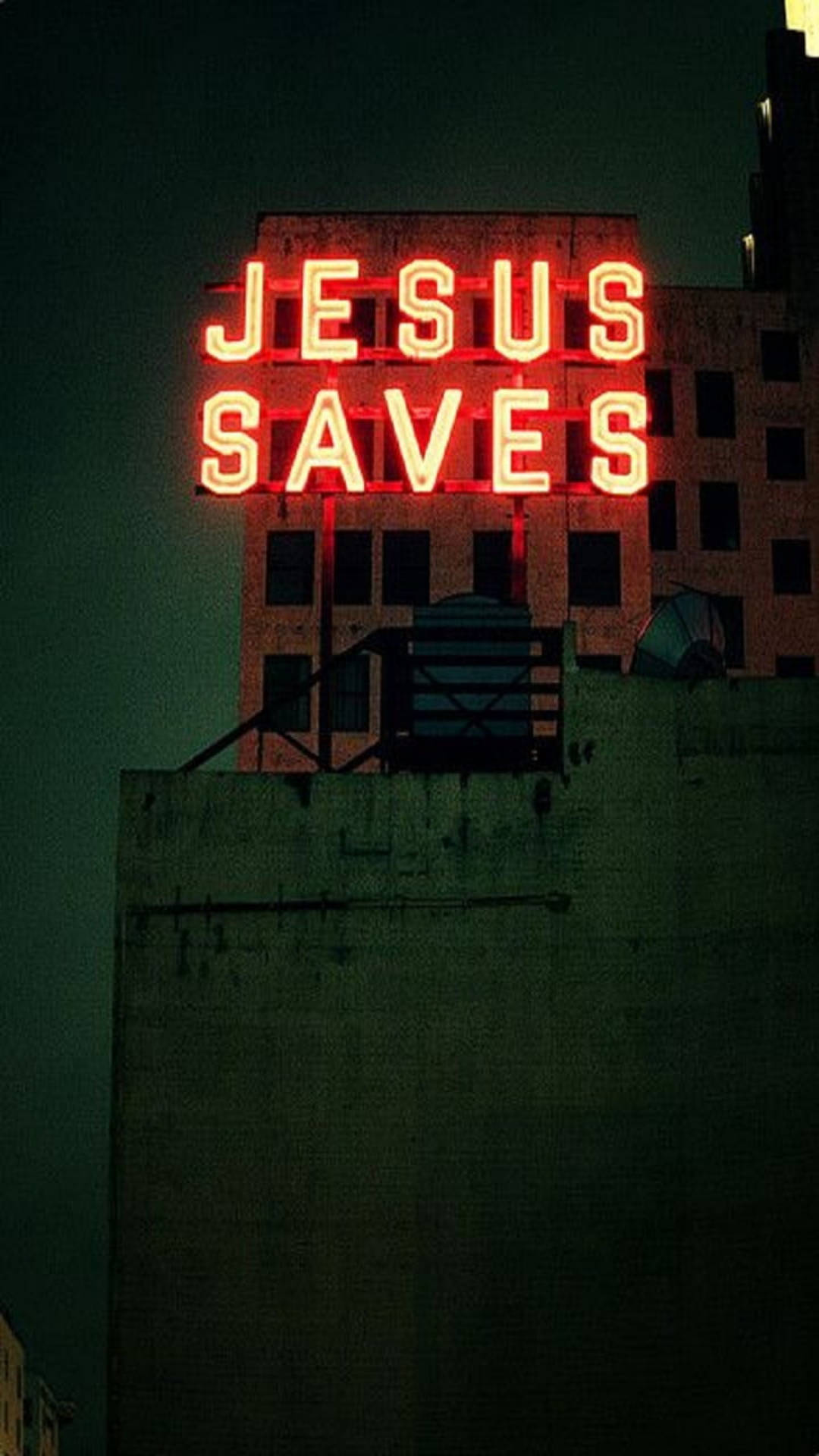 夜間城市建築物上寫著「Jesus Saves」的紅色霓虹燈牌。