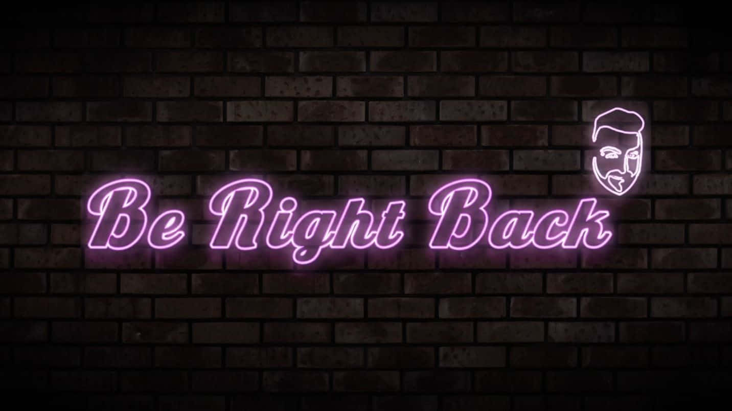 夜間磚牆上寫著「Be Right Back」並帶有臉部圖標的紫色霓虹燈牌。