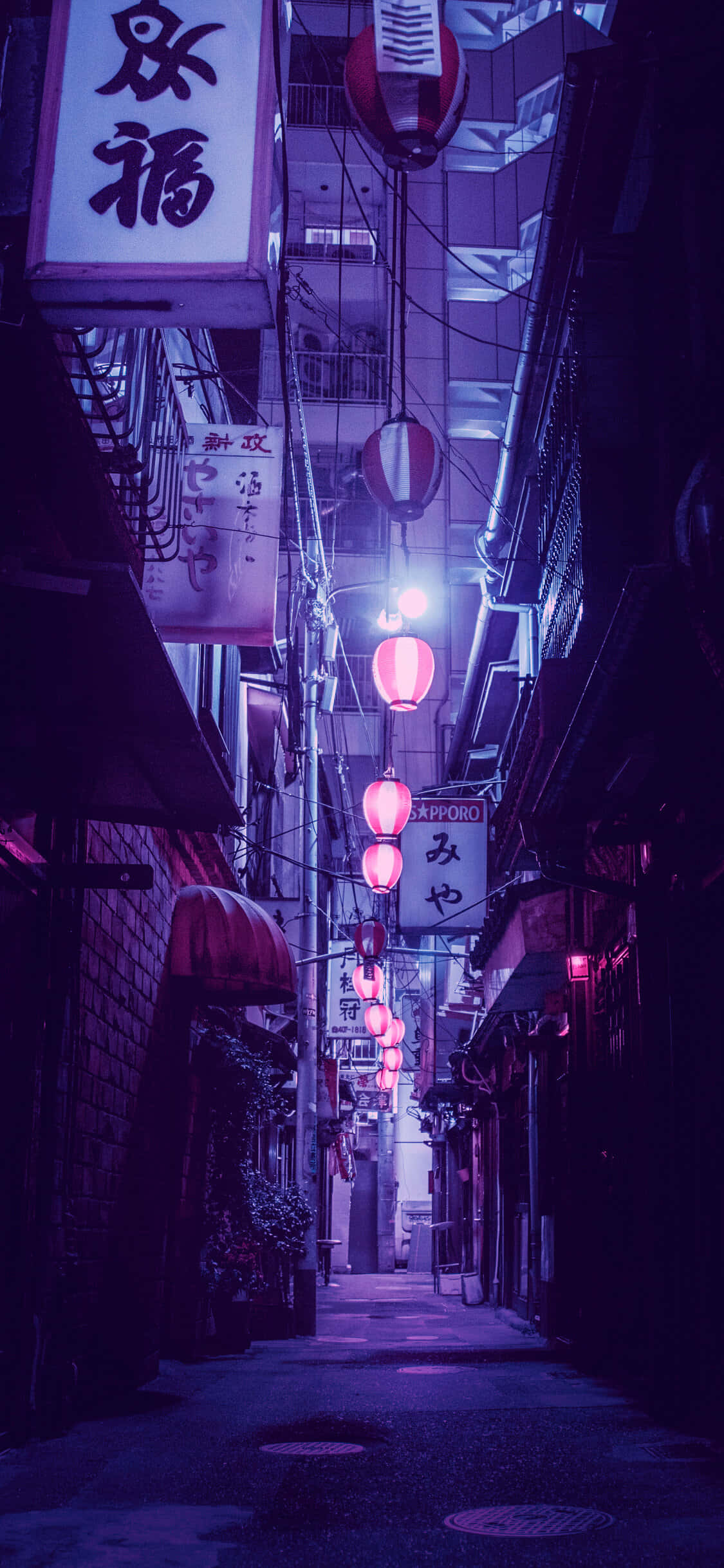 霓虹紫調東京小巷手機壁紙 壁紙 — 日本夜晚一條狹窄的霓虹燈小巷，發光的粉紅色燈籠和傳統招牌在潮濕的路面上投射出紫色色調。
