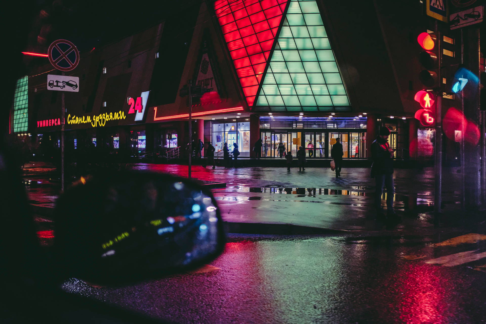 霓虹燈光在雨夜的城市中反射在濕漉漉的人行道上。