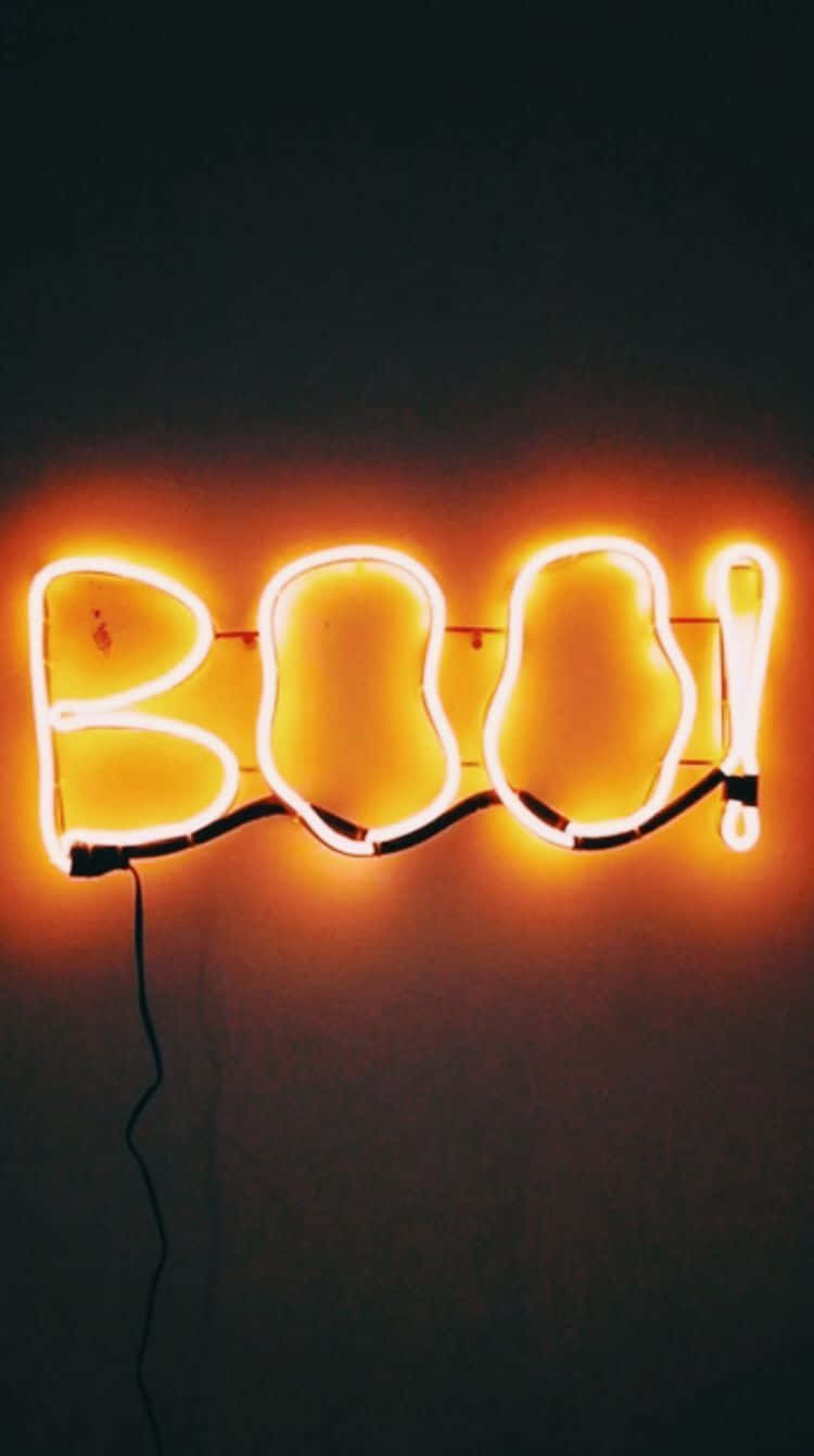 發光的橙色霓虹燈牌，在黑暗的牆壁上拼寫著BOO。