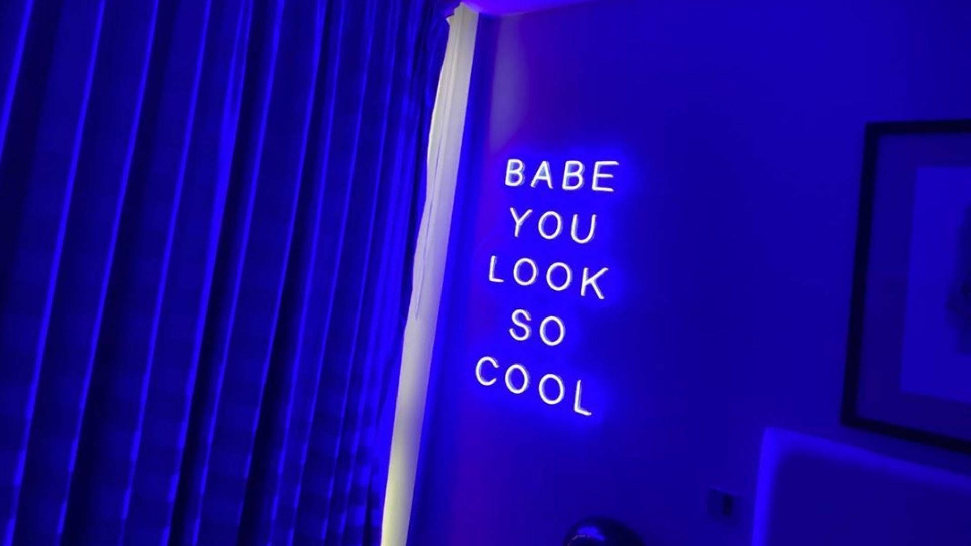 霓虹燈牌寫著 babe you look so cool，喺一個藍色燈光嘅房間。