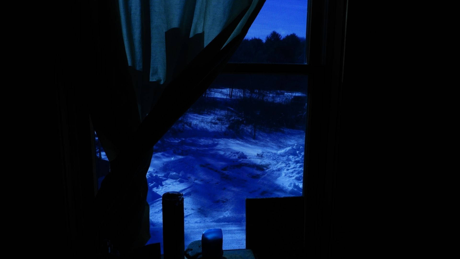 暮色藍天下雪覆蓋地面的剪影窗景