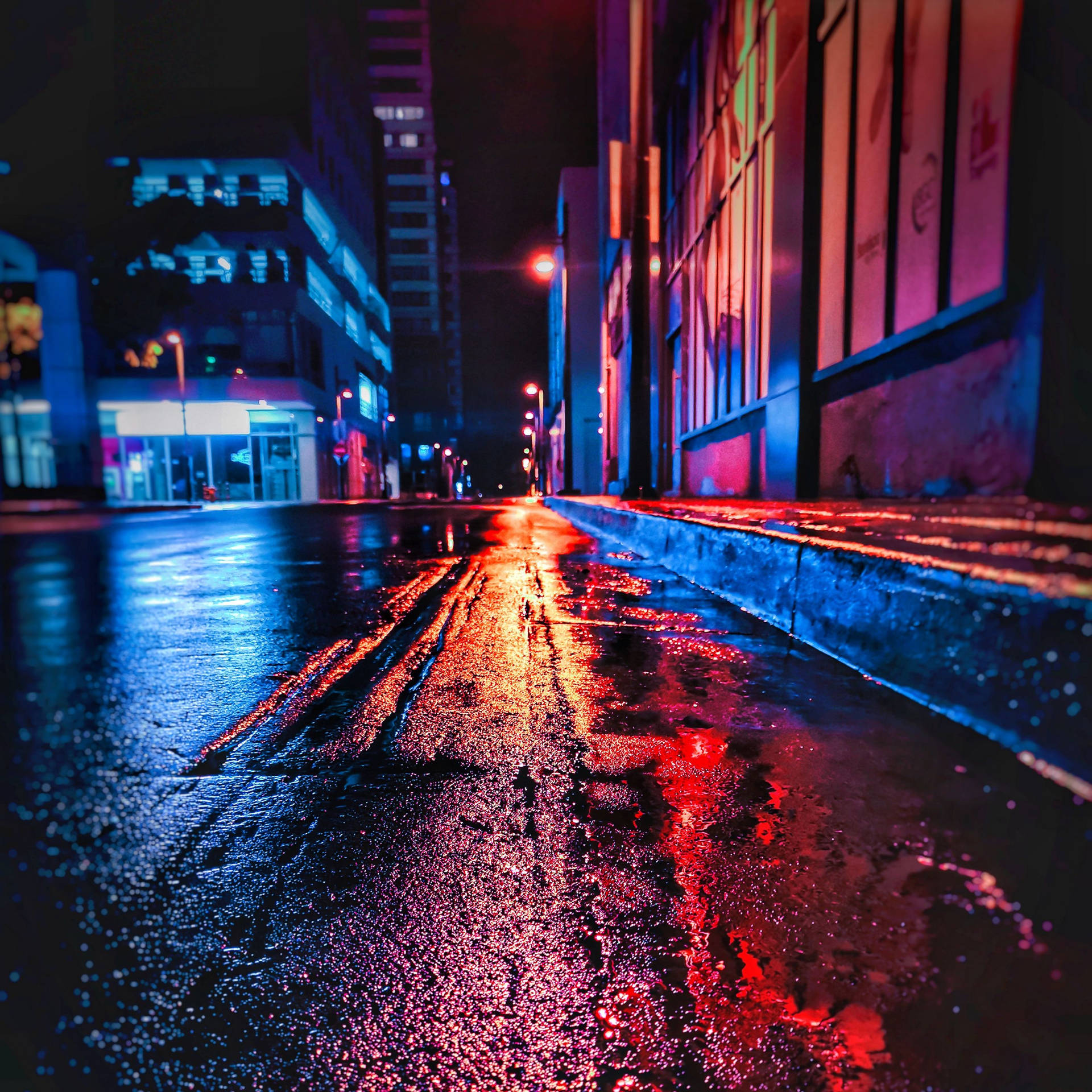 雨濕的城市街道在夜晚閃爍著霓虹燈光。