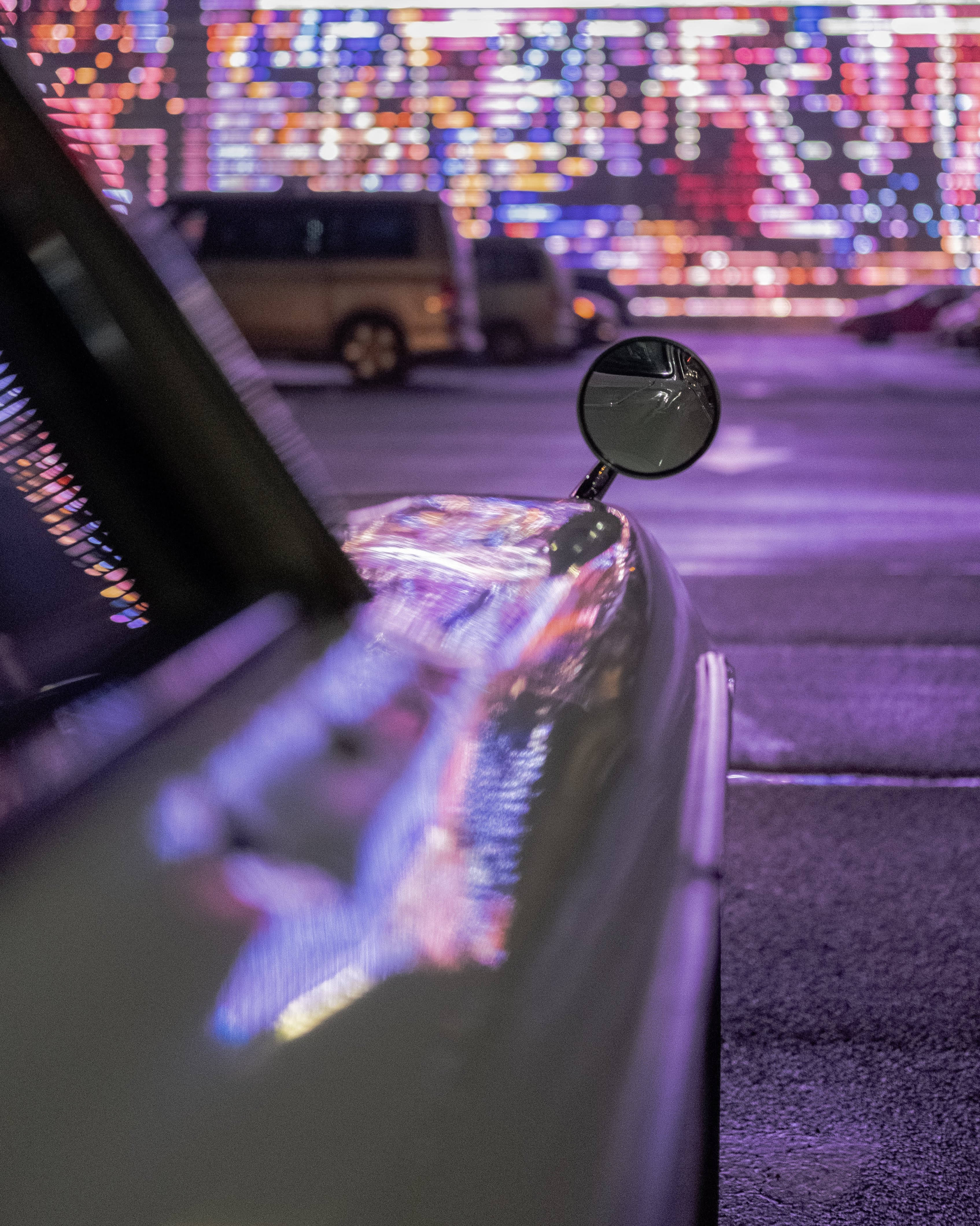 霓虹跑車側鏡 壁紙 — 汽車的側鏡和引擎蓋反射出璀璨夜景中充滿活力的散景燈光。