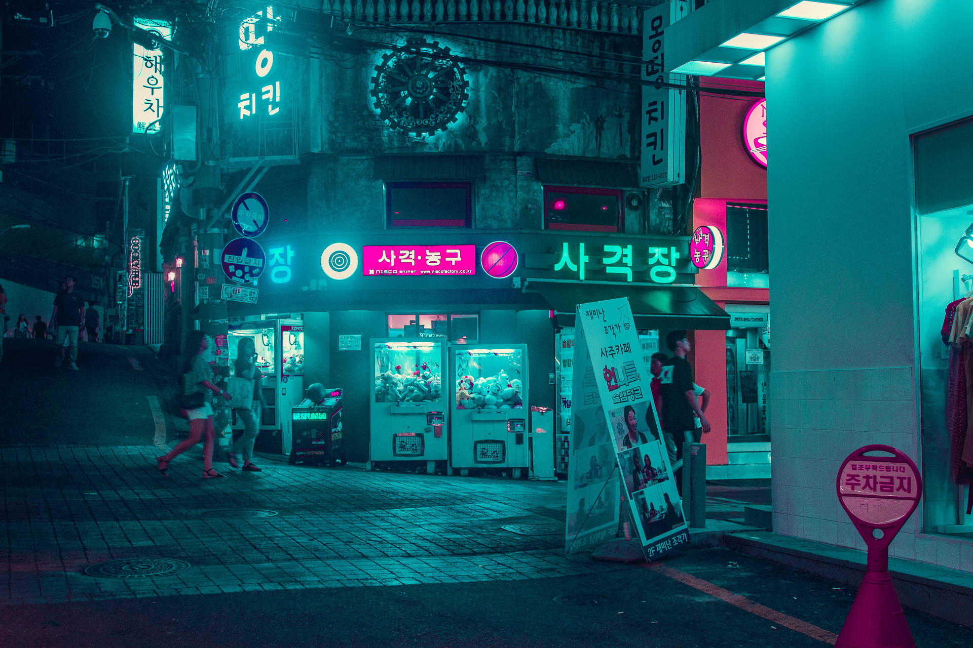 韓國街道夜景，有發光霓虹招牌同夾公仔機。