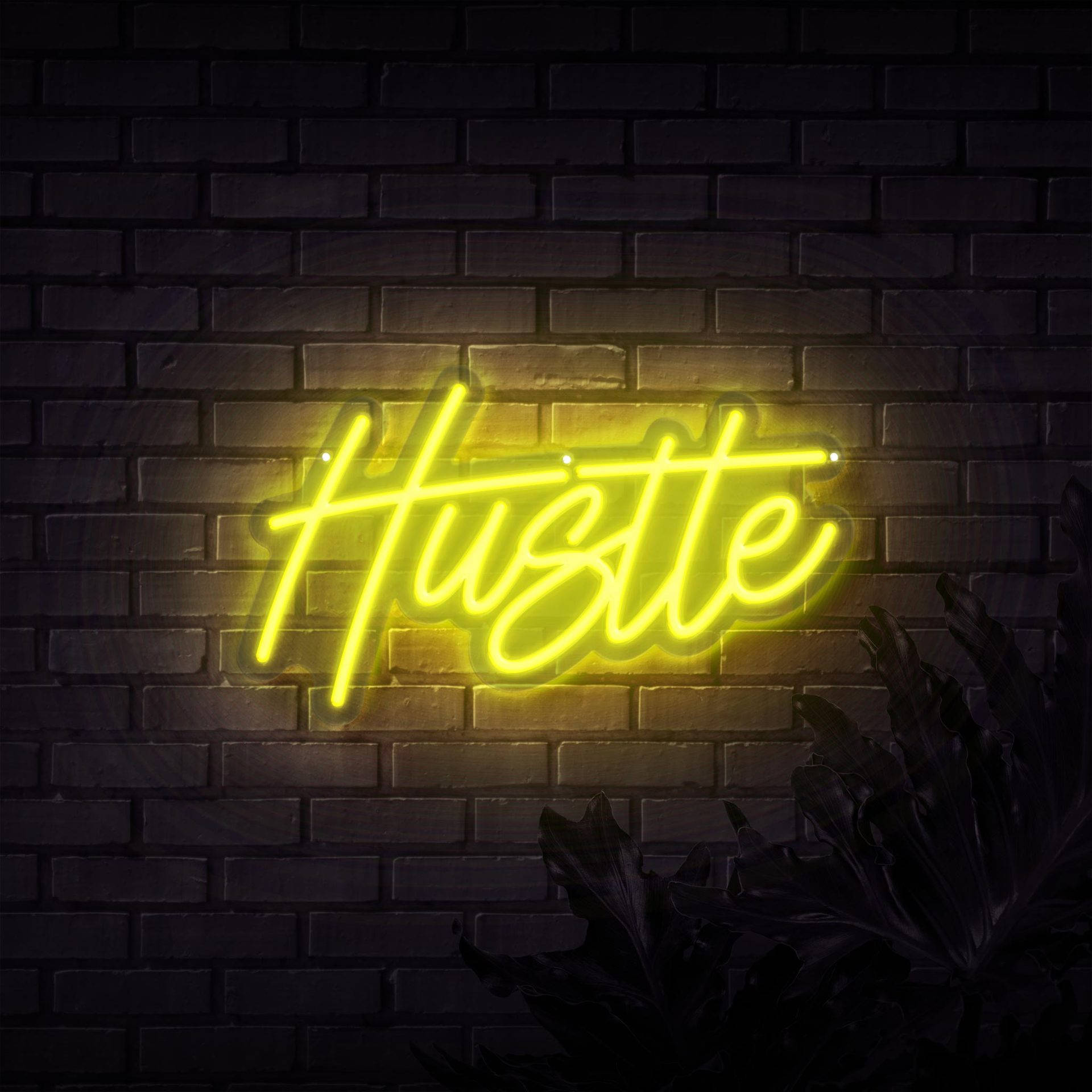 霓虹黃色「Hustle」牆面印刷 壁紙 — 一個發光的黃色霓虹燈牌，拼寫著「Hustle」，照亮了深色磚牆，下方有剪影葉子。