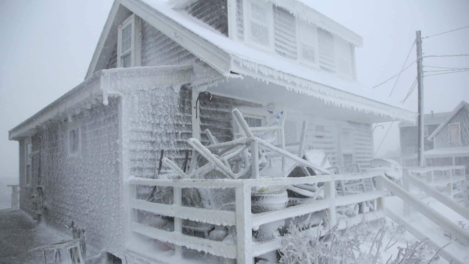 霜雪覆蓋整棟房屋 壁紙 — 一間歷經風霜的房屋和門廊在暴風雪和濃霧中完全被厚厚的冰雪覆蓋。