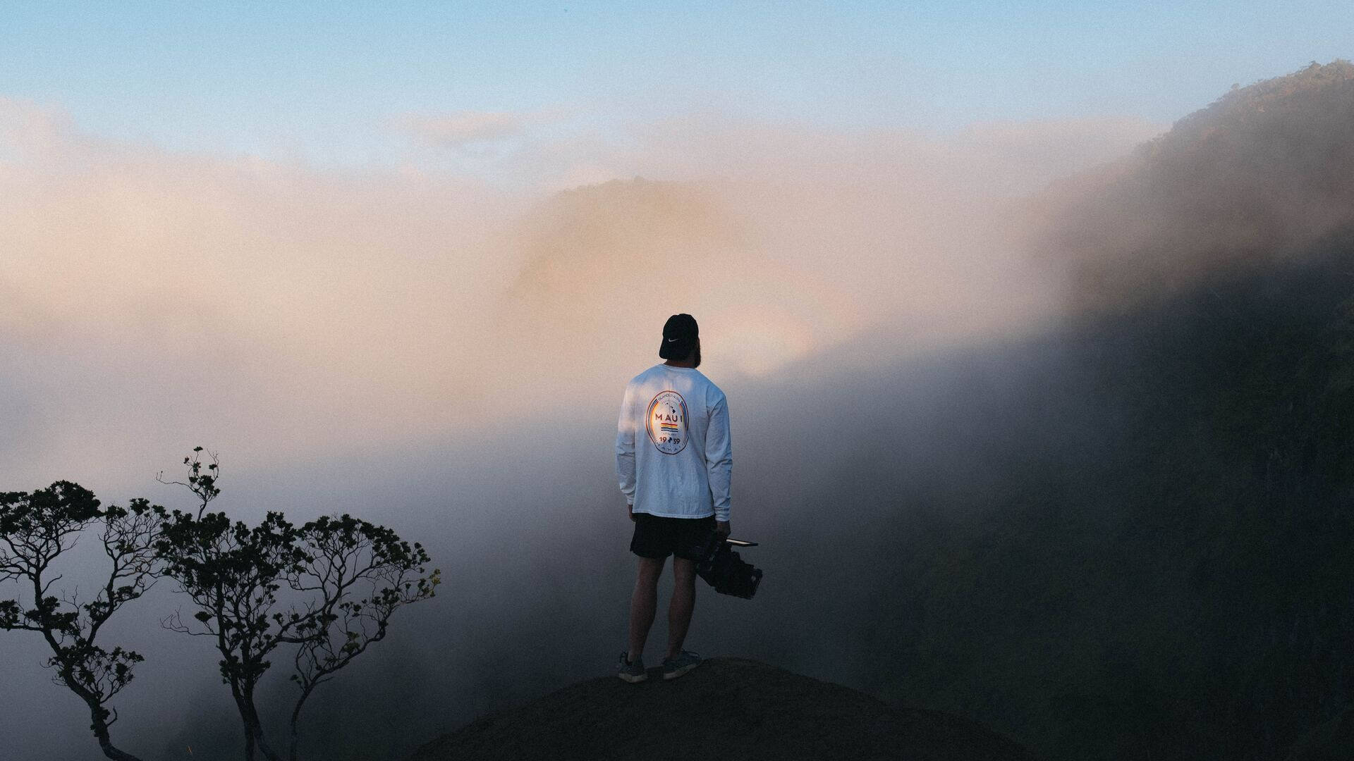黎明時分站在山頂俯瞰雲海的人