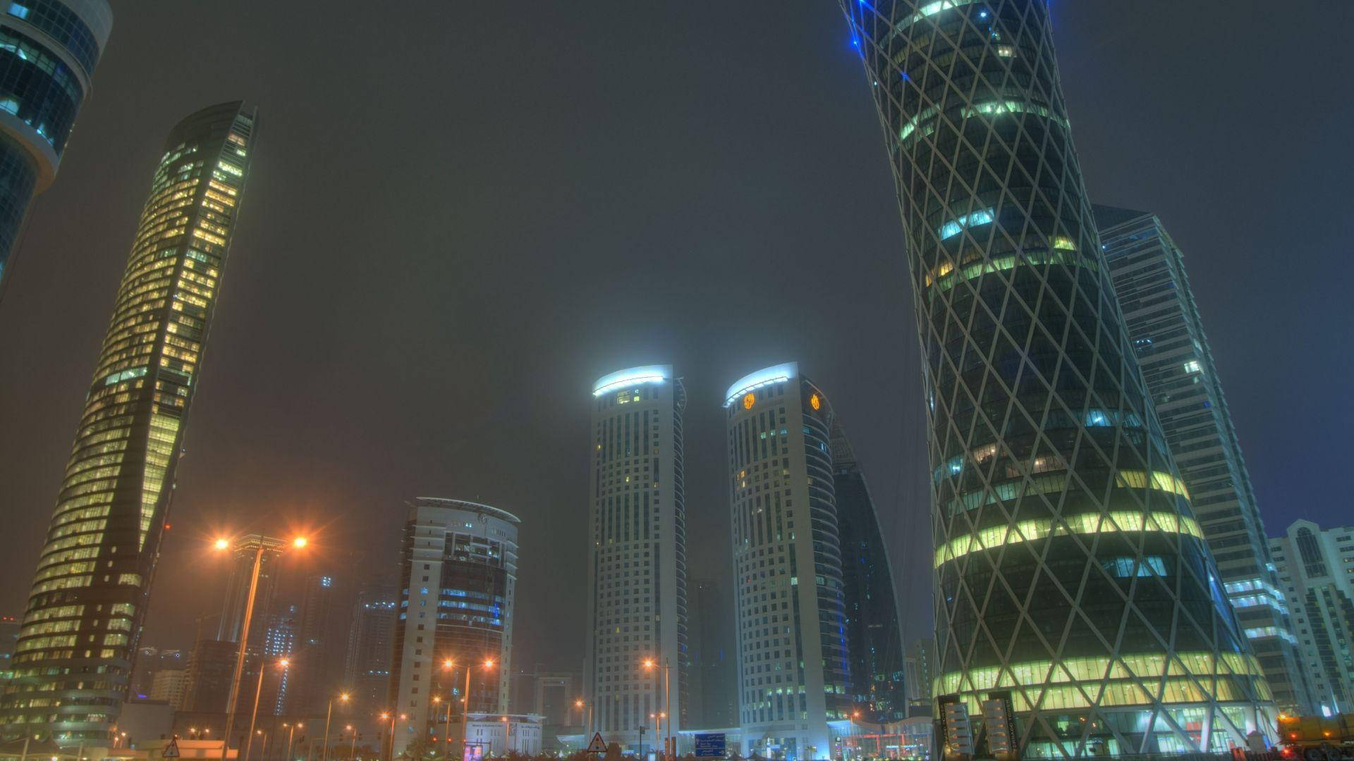 夜晚霧氣瀰漫的城市天際線，閃爍的高樓大廈和街燈。