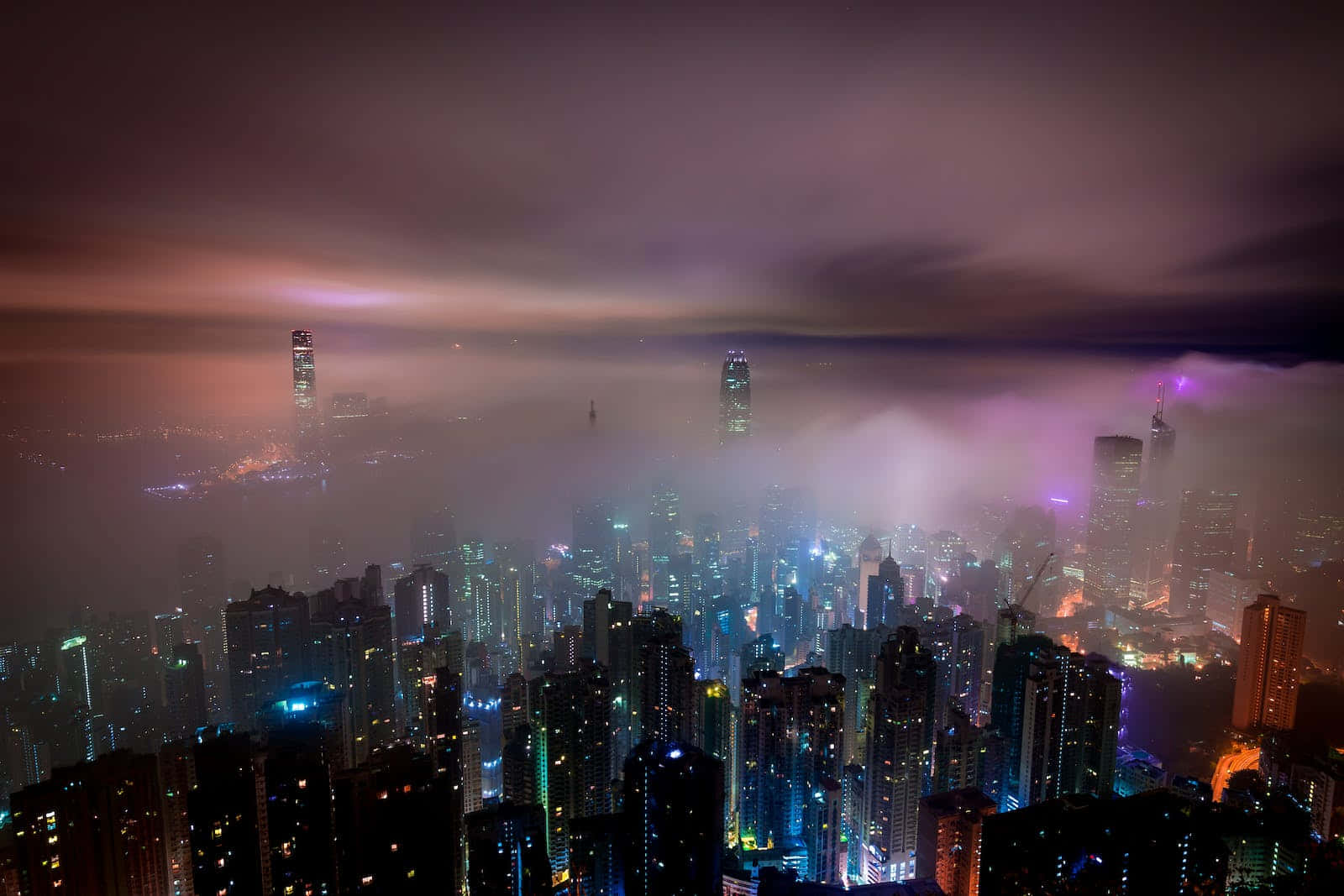 夜晚中發光的城市，摩天大樓從霧氣中浮現，天空呈紫色。