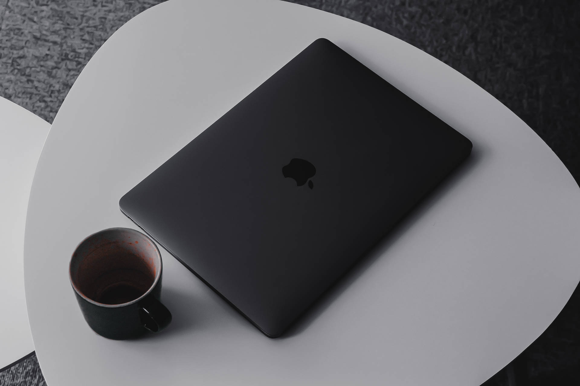 白色桌子上的黑色手提電腦和咖啡杯