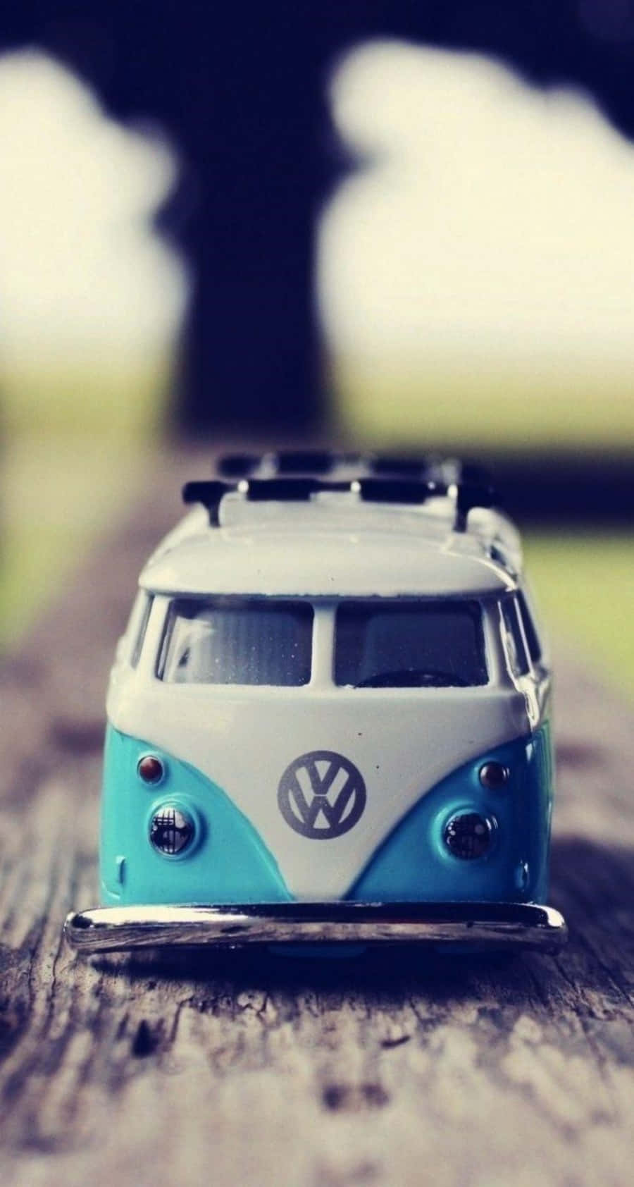 一架復古藍色和白色的VW貨車玩具在木質表面上。