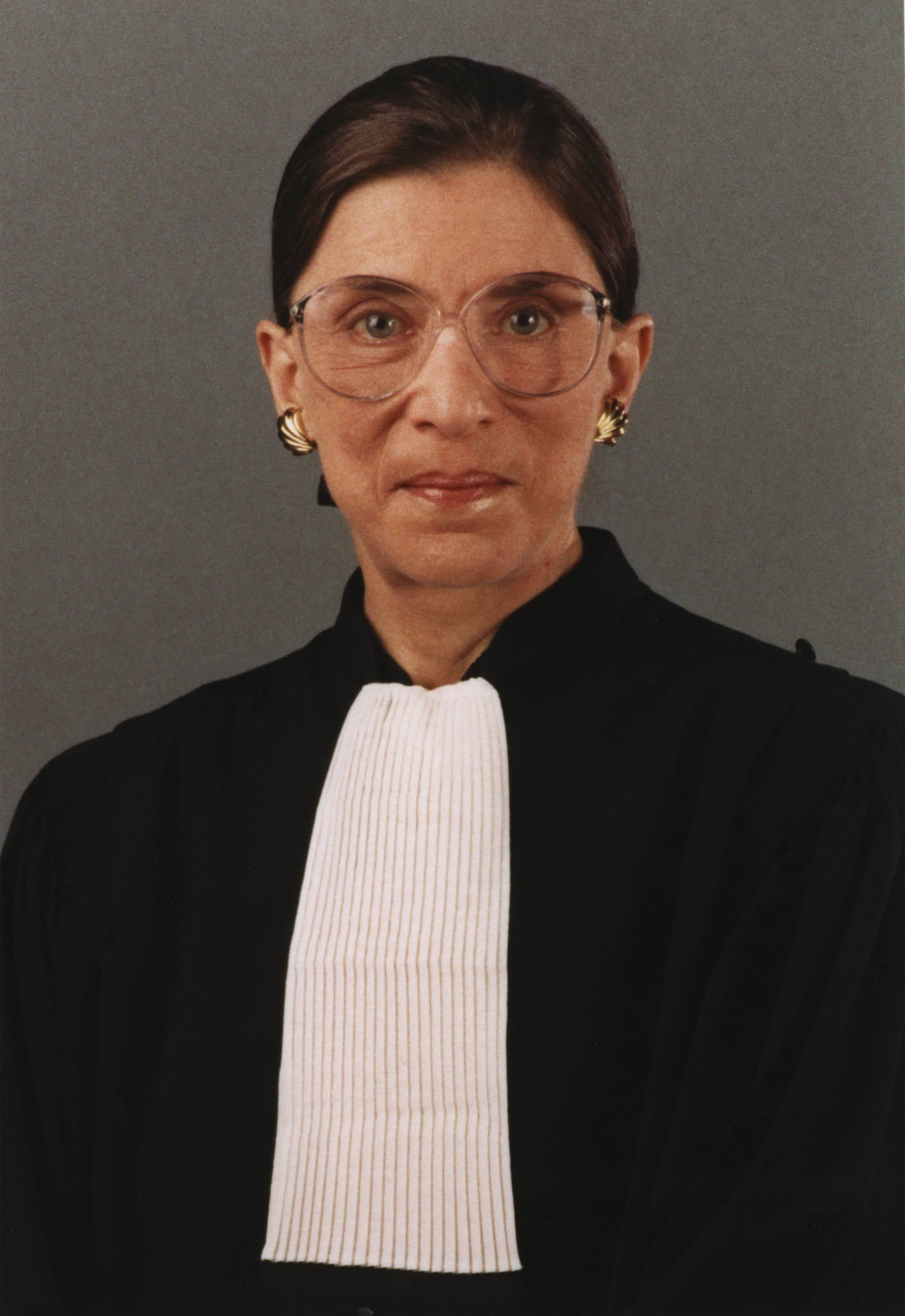 露絲·巴德·金斯伯格正式肖像照 壁紙 — Ruth Bader Ginsburg 身穿司法長袍、白色領飾和金色耳環，以灰色背景為襯的肖像。