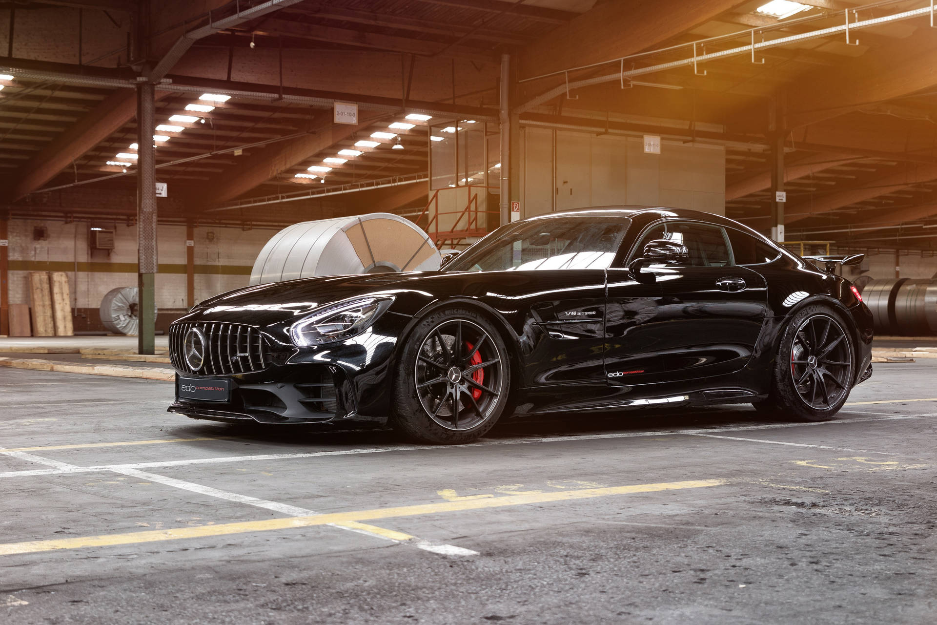 黑色 Mercedes-AMG GT 跑車停泊在工業倉庫中。