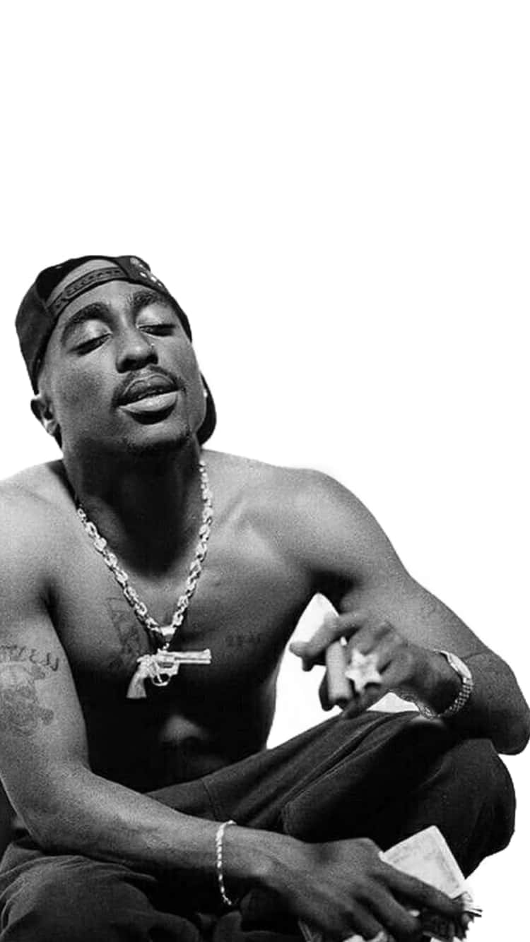 Tupac Shakur 赤裸上身坐著，閉上眼睛，戴著鏈條和帽子。