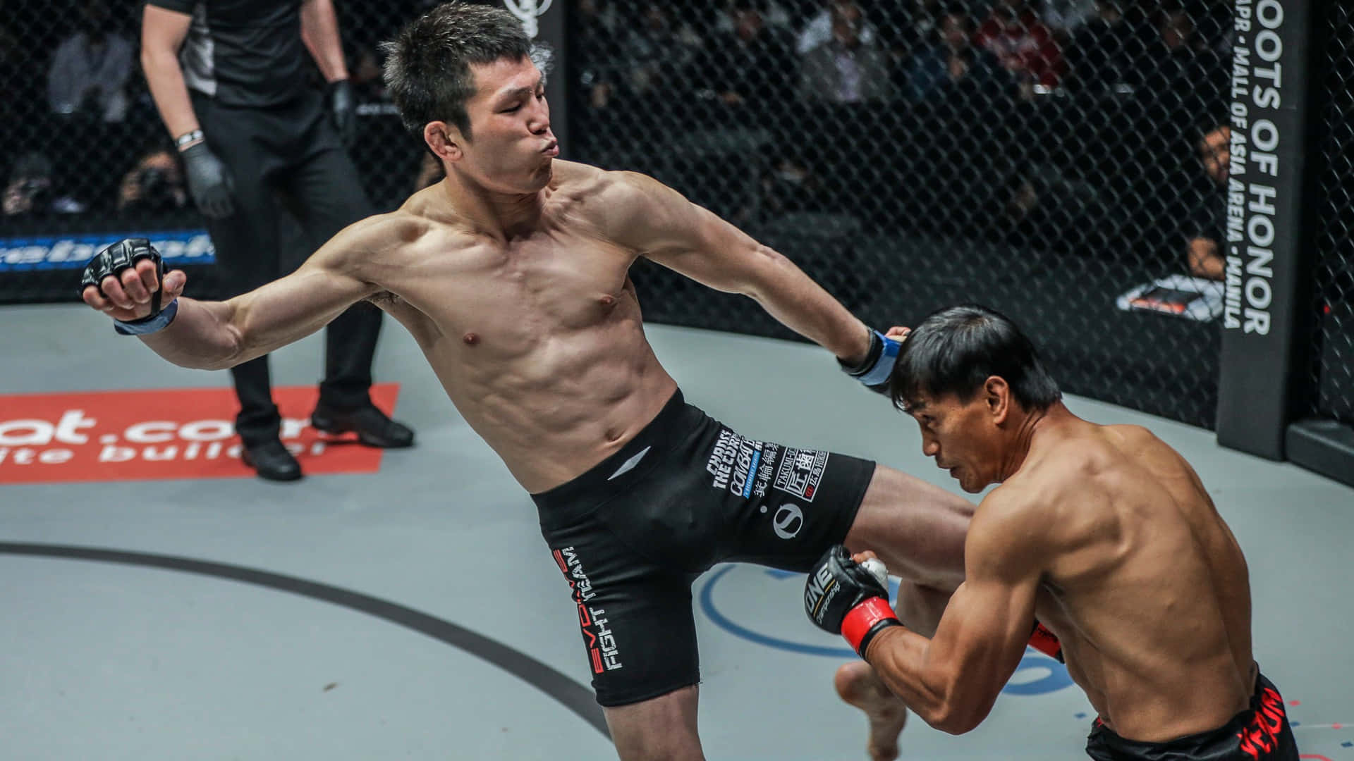 青木真也對戰Eduard Folayang激烈對決 壁紙 — 一位肌肉發達的拳手在燈光明亮的MMA籠中向對手踢出高踢，背景有觀眾。