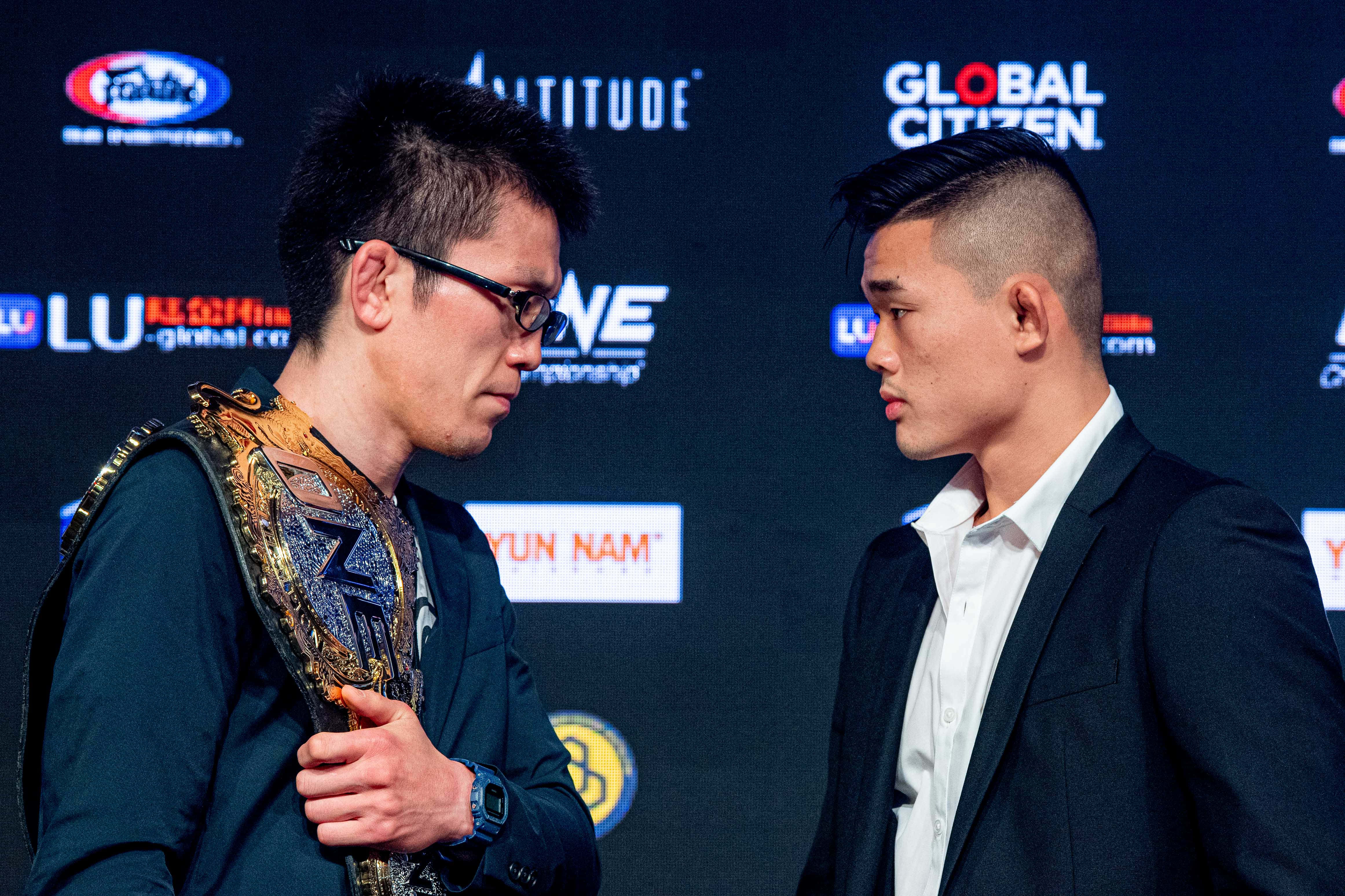 青木真也與Christian Lee於ONE Championship: Enter The Dragon記者會對峙 壁紙 — 兩名拳手在記者會上對峙，一人手持冠軍腰帶，另一人則怒目而視。
