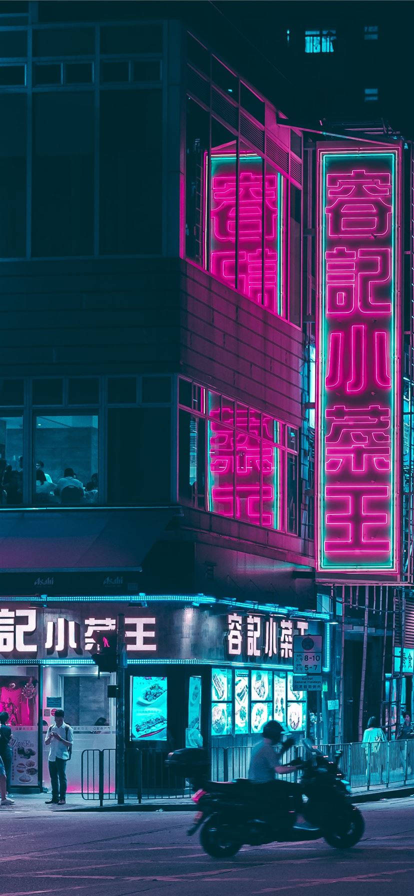 青色城市夜景霓虹燈 壁紙 — 鮮豔的粉紅色和青色霓虹燈在夜晚的城市建築物上閃耀，一輛滑板車在潮濕的街道上行駛而過。