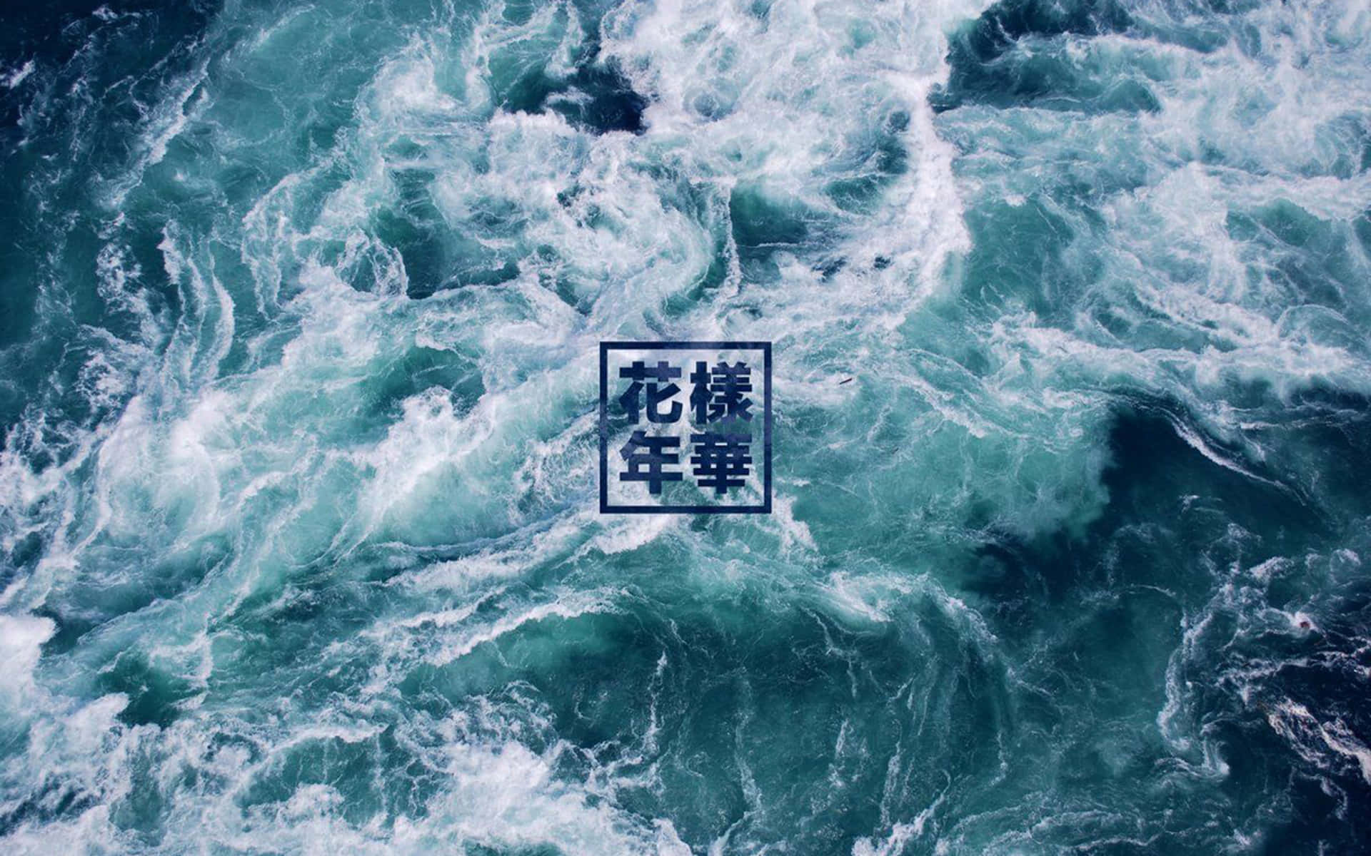 從上方觀看，洶湧的海浪以藍綠色和白色泡沫旋轉。
