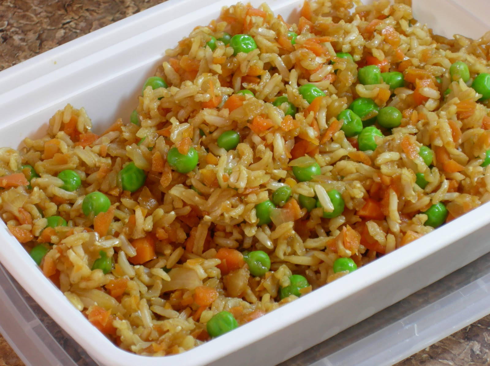 青豆炒飯 壁紙 — 白色外賣容器中色彩鮮豔的炒飯配青豆和橙色胡蘿蔔的特寫。