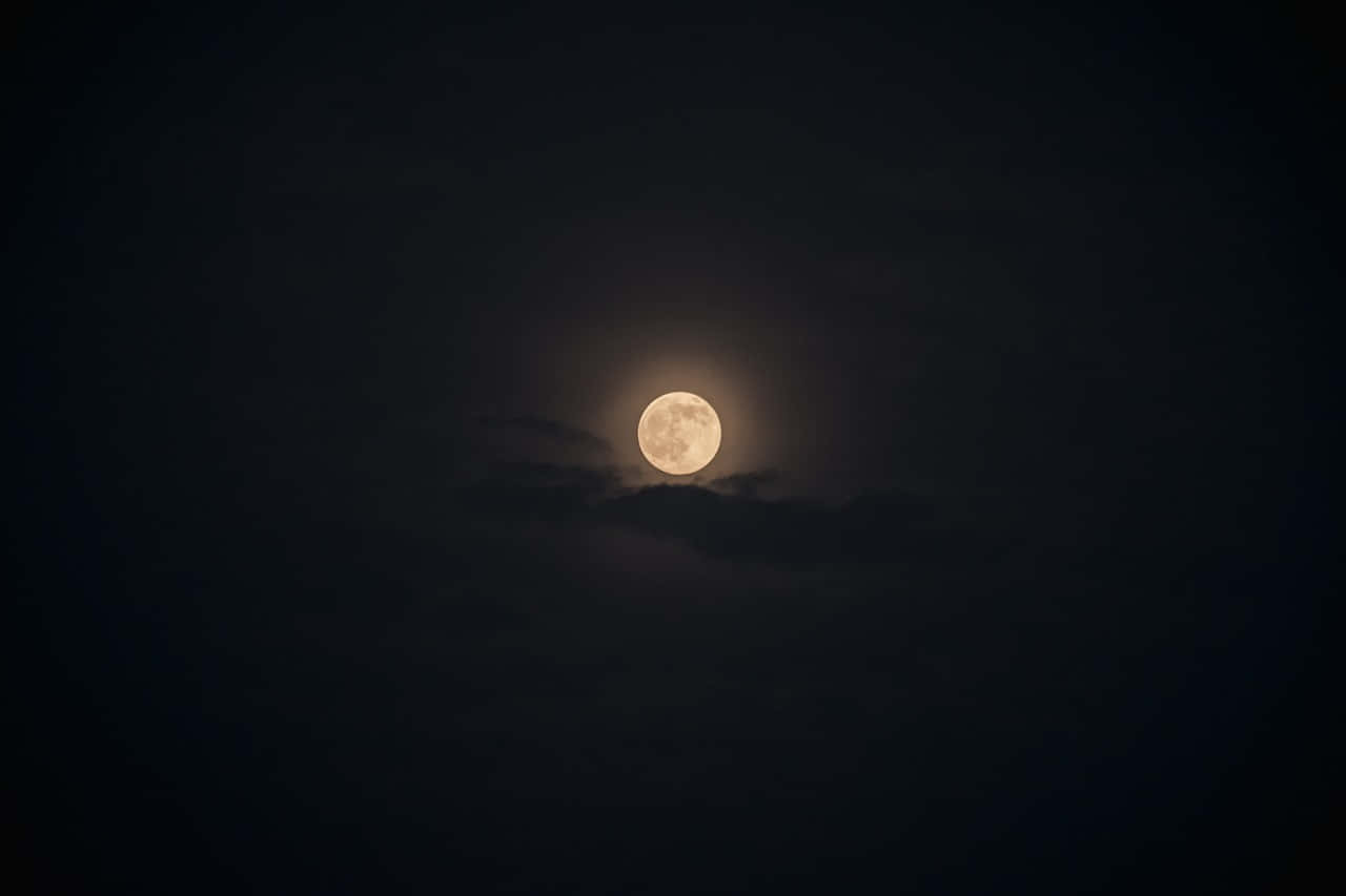 靜心欣賞夜色的寧靜 壁紙 — 一輪明亮的滿月透過薄雲柔和地發光，映襯著深邃天鵝絨般的夜空。