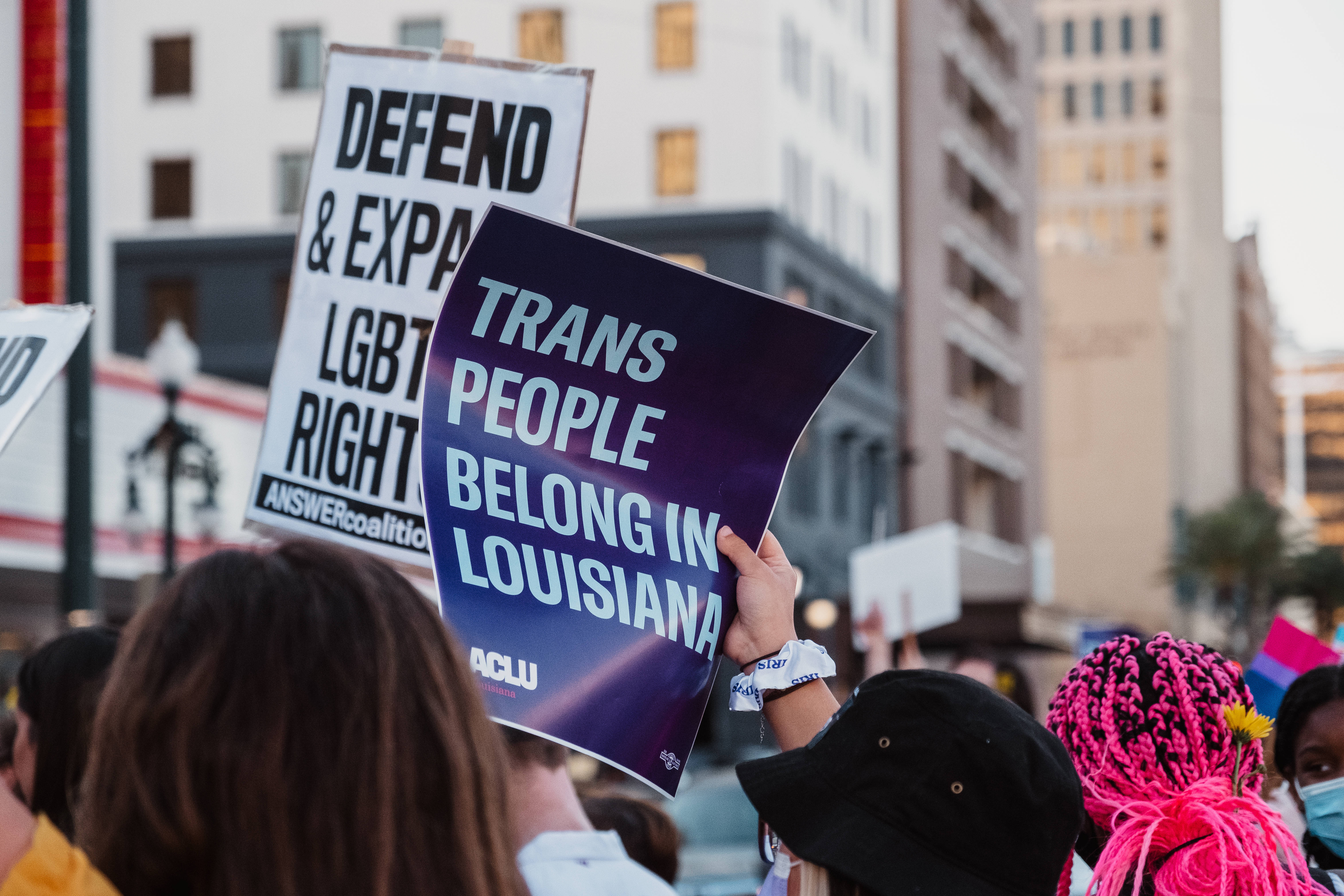 非二元人士為LGBT權益抗議 壁紙 — 抗議者在城市街頭示威中高舉支持LGBTQ權利和跨性別包容的標語。