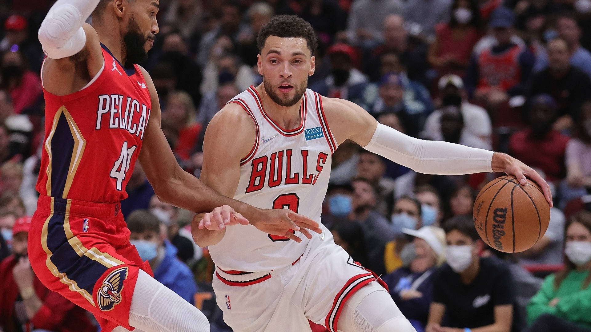 非凡NBA球星扎克·拉文 壁紙 — 芝加哥公牛隊球員在激烈的NBA比賽中運球，同時被新奧爾良鵜鶘隊球員緊密防守。