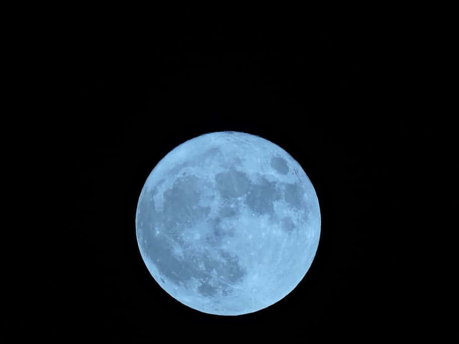 非凡滿月照亮夜空 壁紙 — 一輪明亮的藍色月亮主宰著一片漆黑的天空，可見隕石坑和月海。