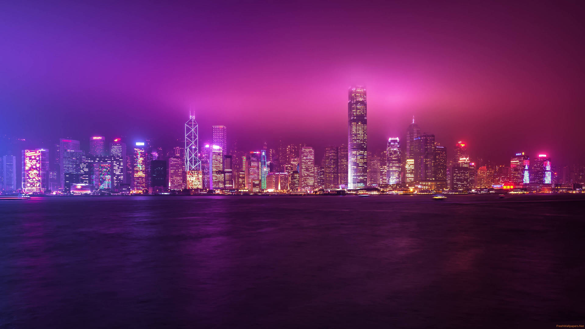 夜晚香港嘅天際線，喺水面上閃爍住紫色同粉紅色嘅霓虹燈光。
