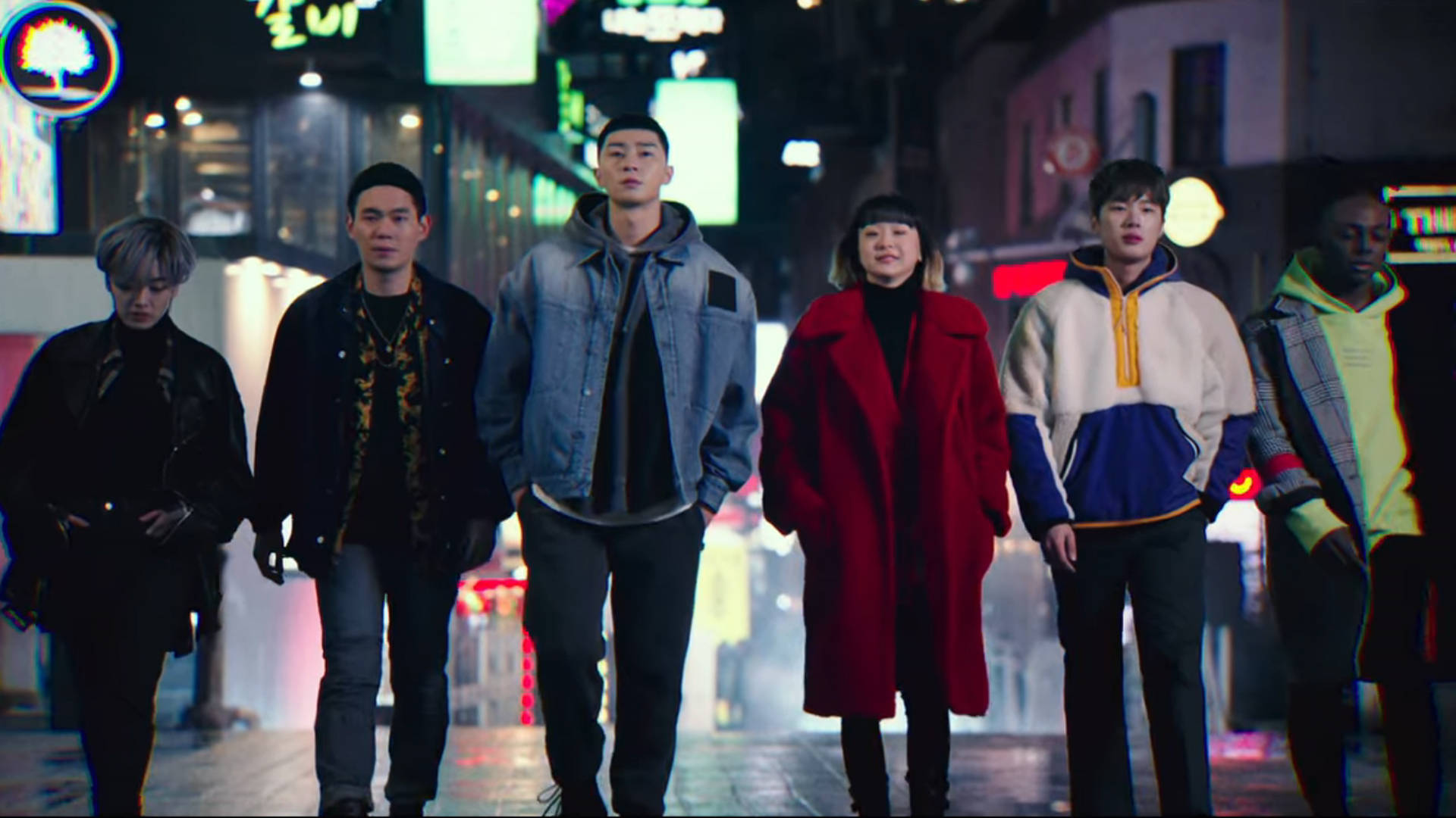 六個年輕成年人夜晚行喺充滿活力嘅霓虹燈城市街道上。