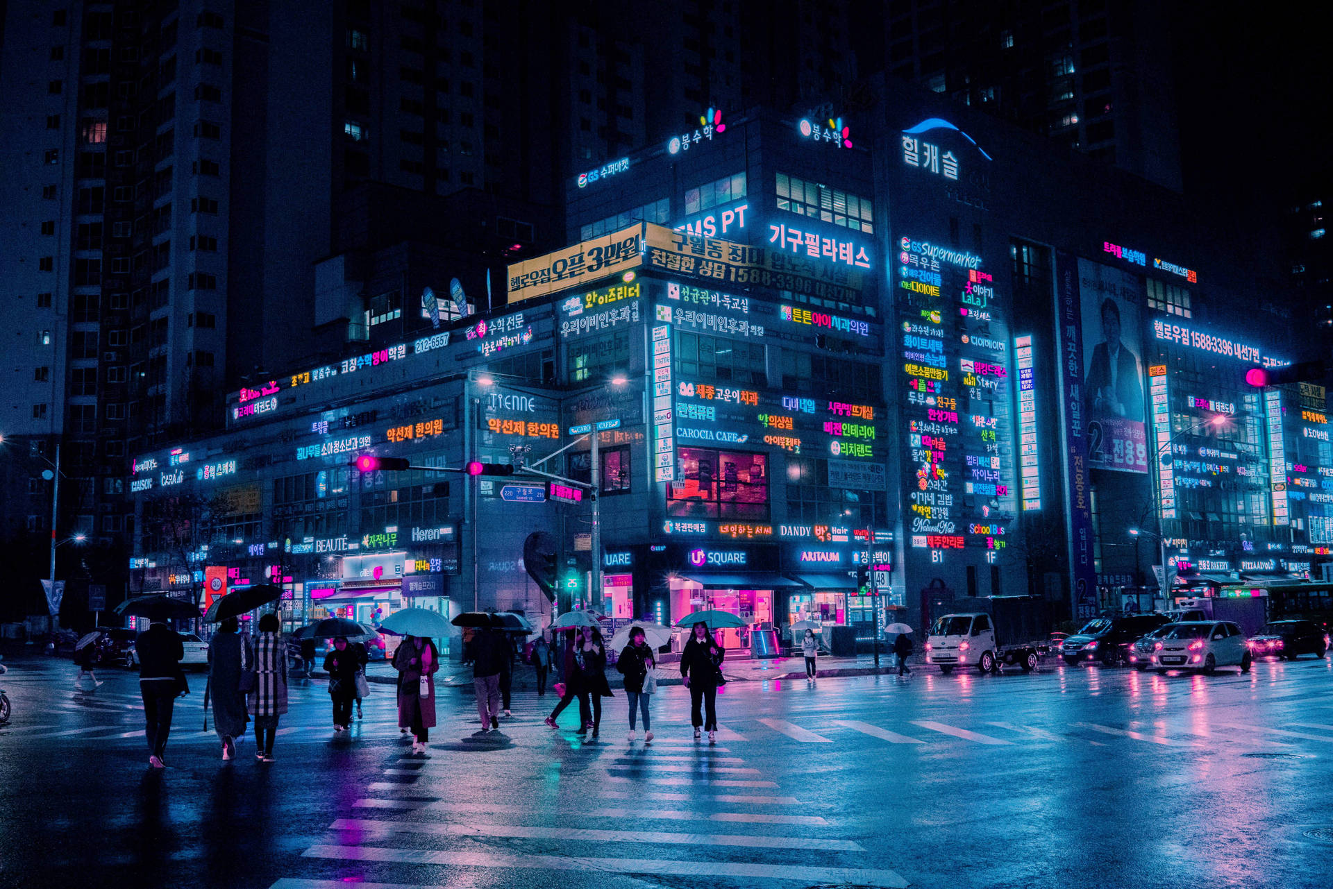行人撐傘在夜晚穿越濕漉漉的霓虹城市街道。