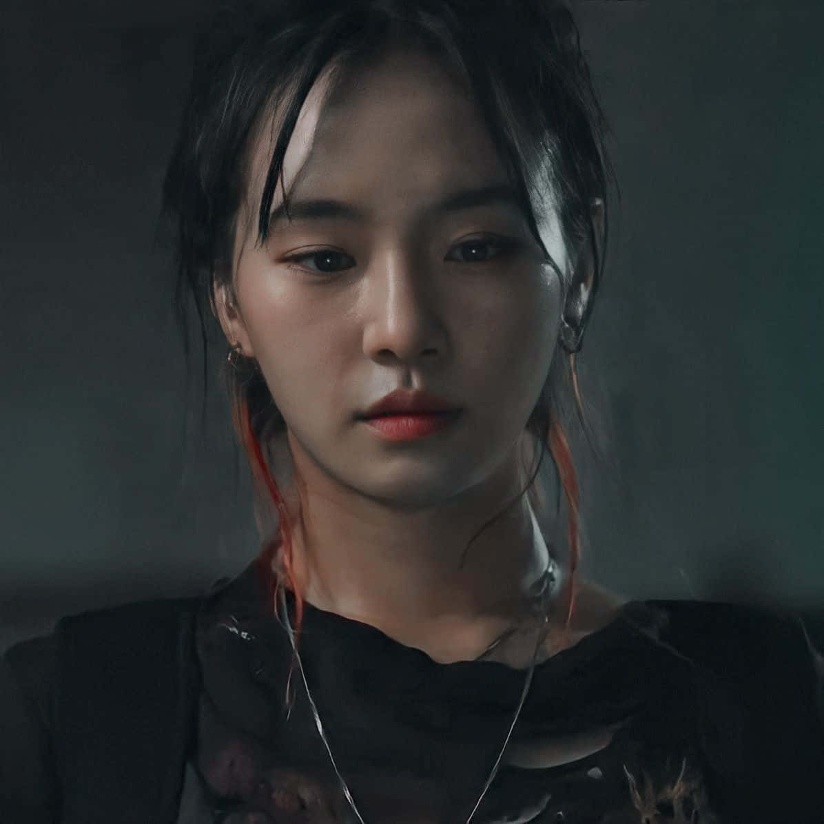 一位深色頭髮帶紅色挑染的年輕女子嚴肅地看著鏡頭。