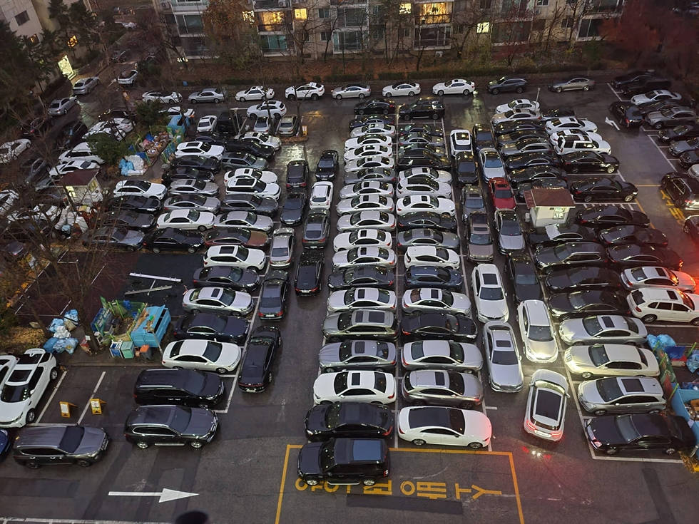 俯瞰黃昏時分擠滿汽車的停車場。