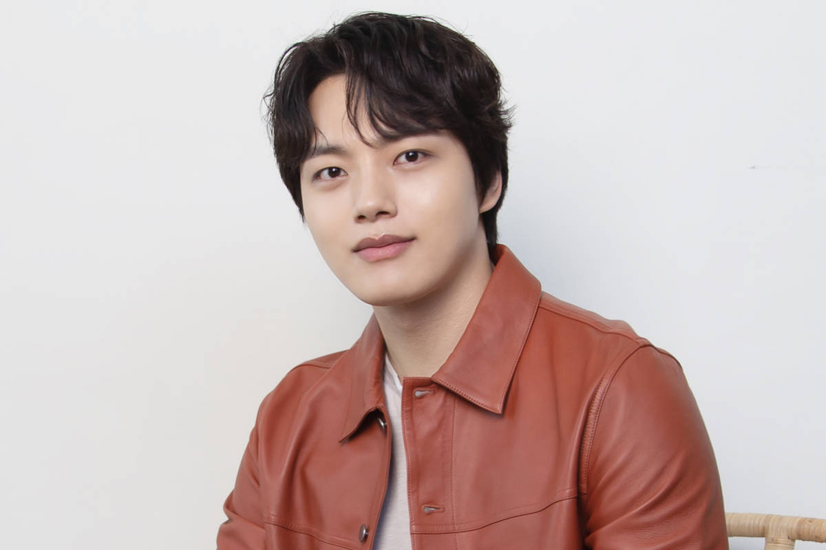韓國演員李陣郁穿時尚皮夾克 壁紙 — 一位黑髮年輕男子穿著棕色皮夾克，背景為純白色。