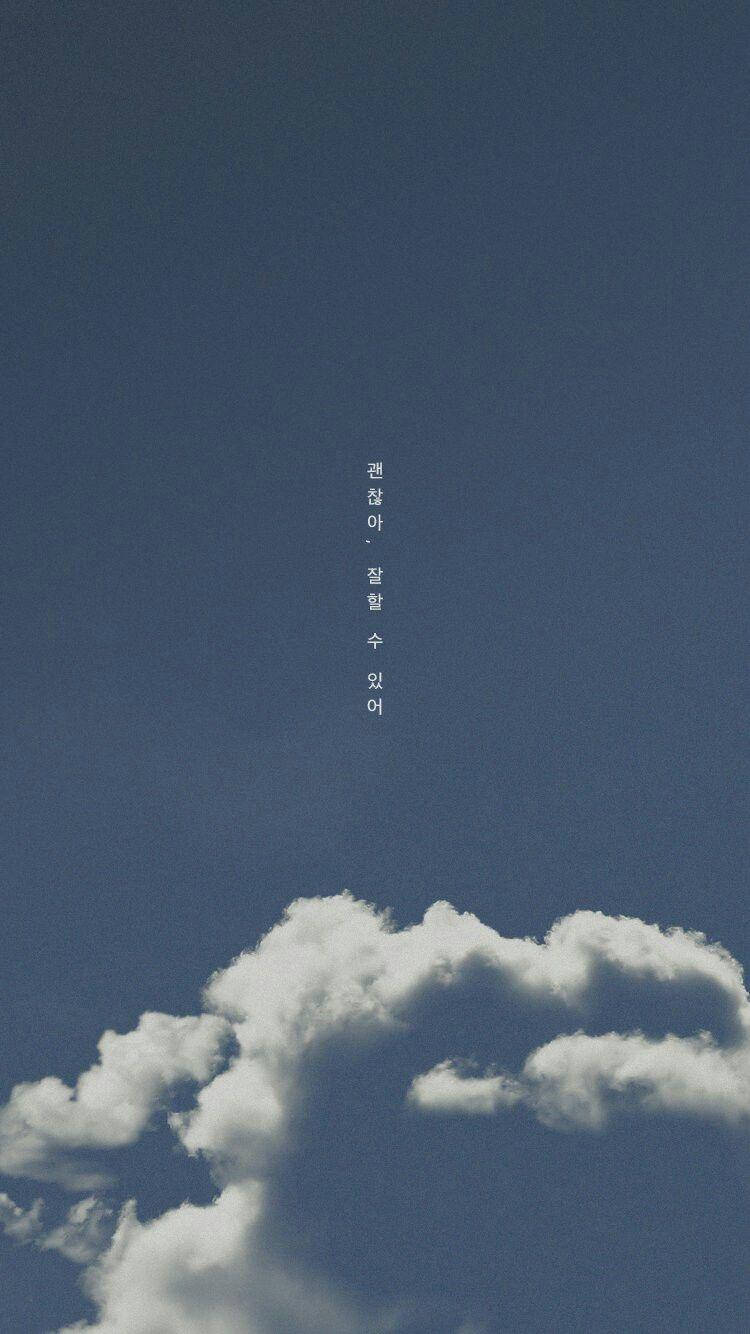 藍天，帶有蓬鬆的白雲和垂直的韓文文字。
